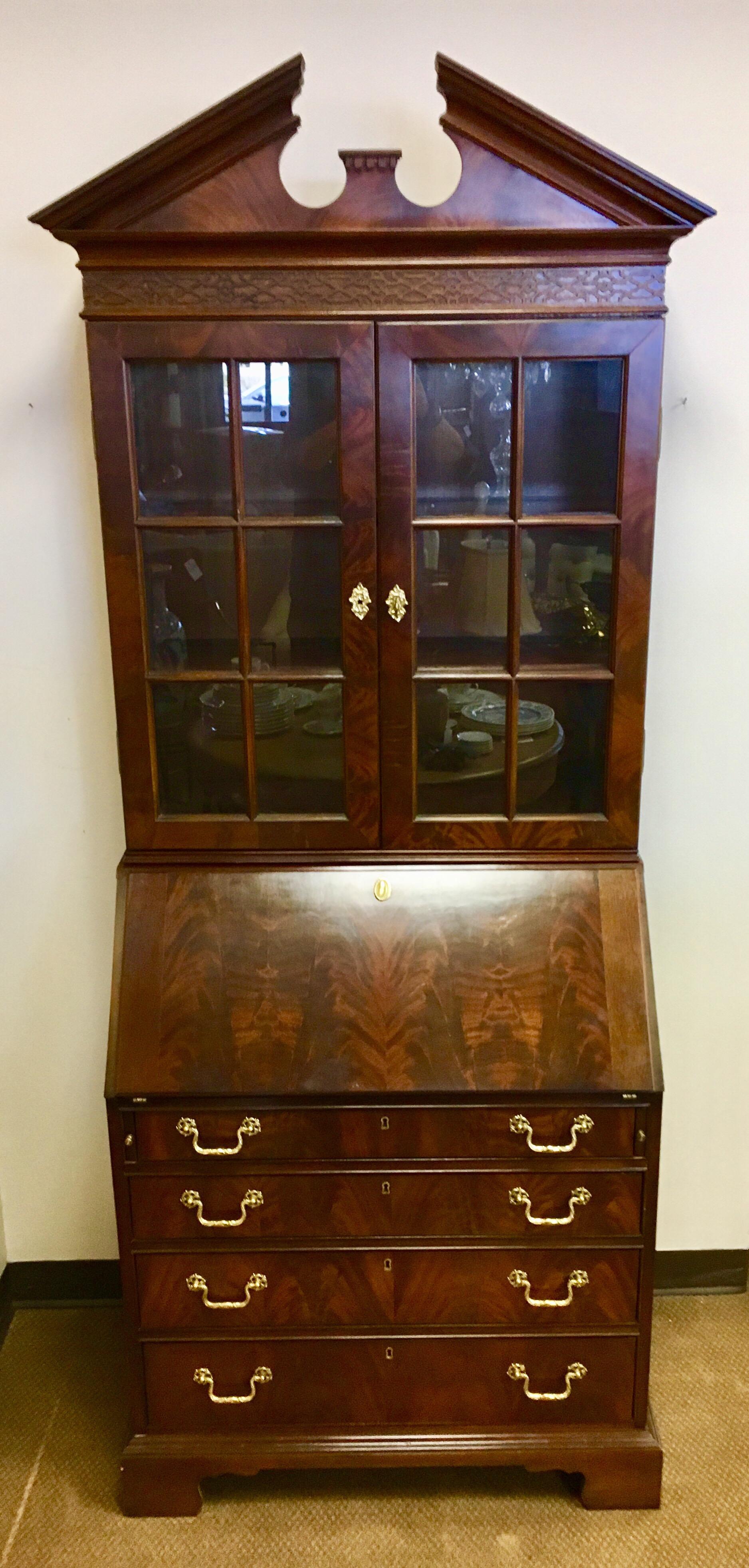 Magnificent George III style flame mahogany secretary bookcase/desk by Councill Craftsman,
circa 1980s, USA. Features four drawers at bottom all adorned with original brass hardware. The top,
which is a separate piece, has glass doors that open to