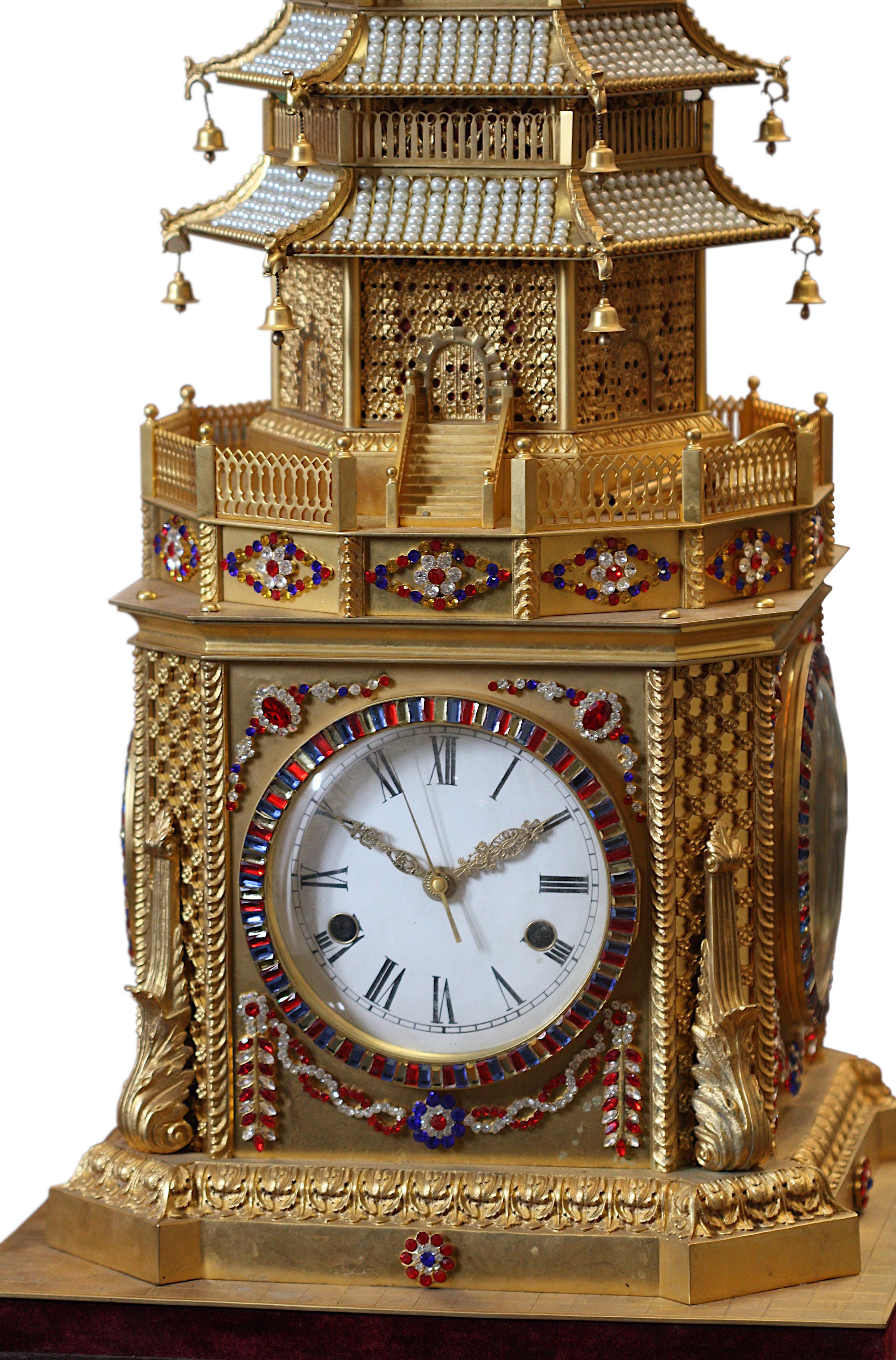 A George III style gilt-bronze musical automaton clock probably made for the Chinese market, of spreading hexagonal form with eight gabled and foliate-pierced tiers hung with bells, color paste set jewels and pearl studded roof tops, measure 92 cm,