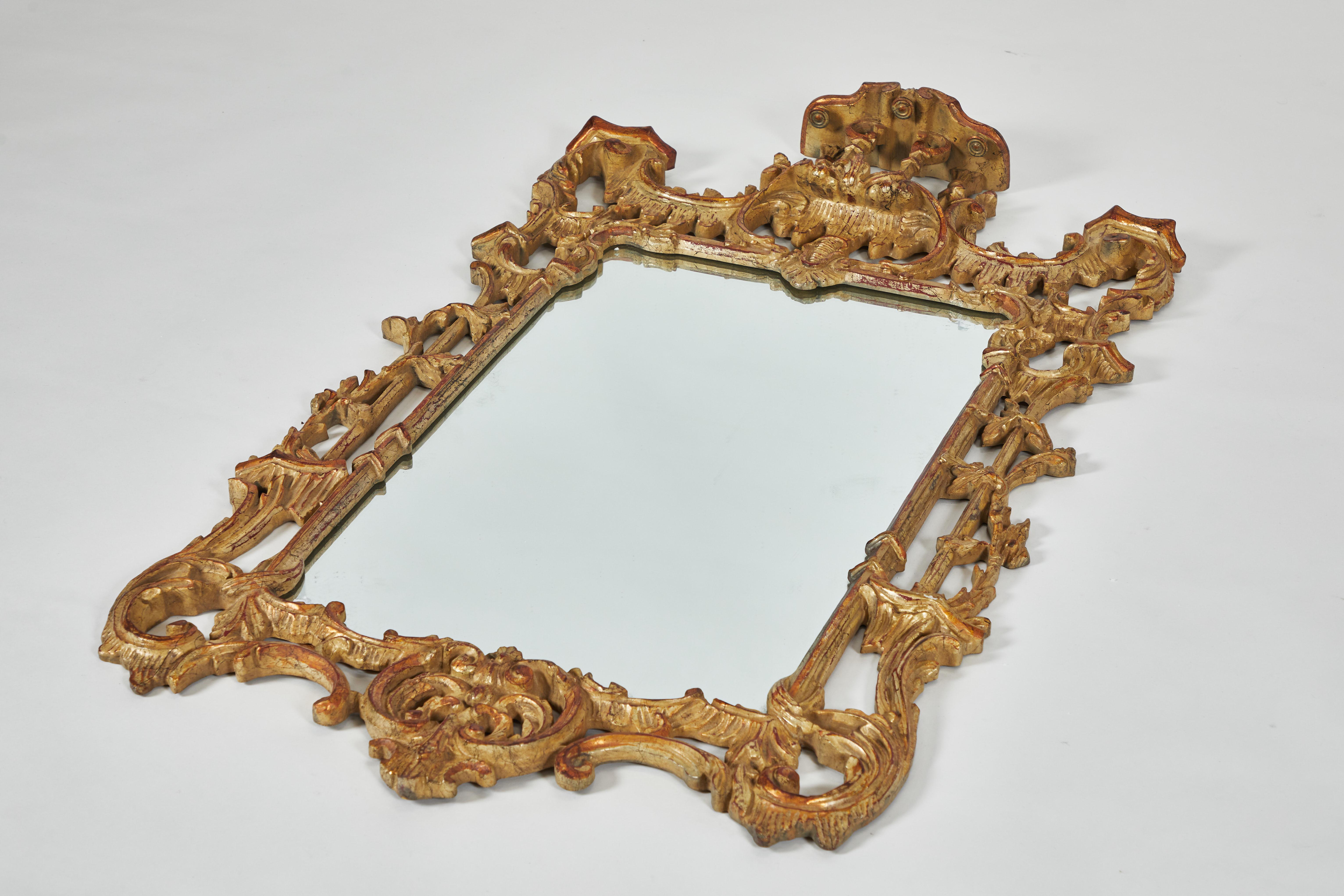 A George III style beautifully carved giltwood wall mirror in the Rococo style in the manner of Thomas Chippendale. A pagoda sits atop the crest above a rectangular mirror plate and surrounded by a scrolling, latticed frame.
20th century.