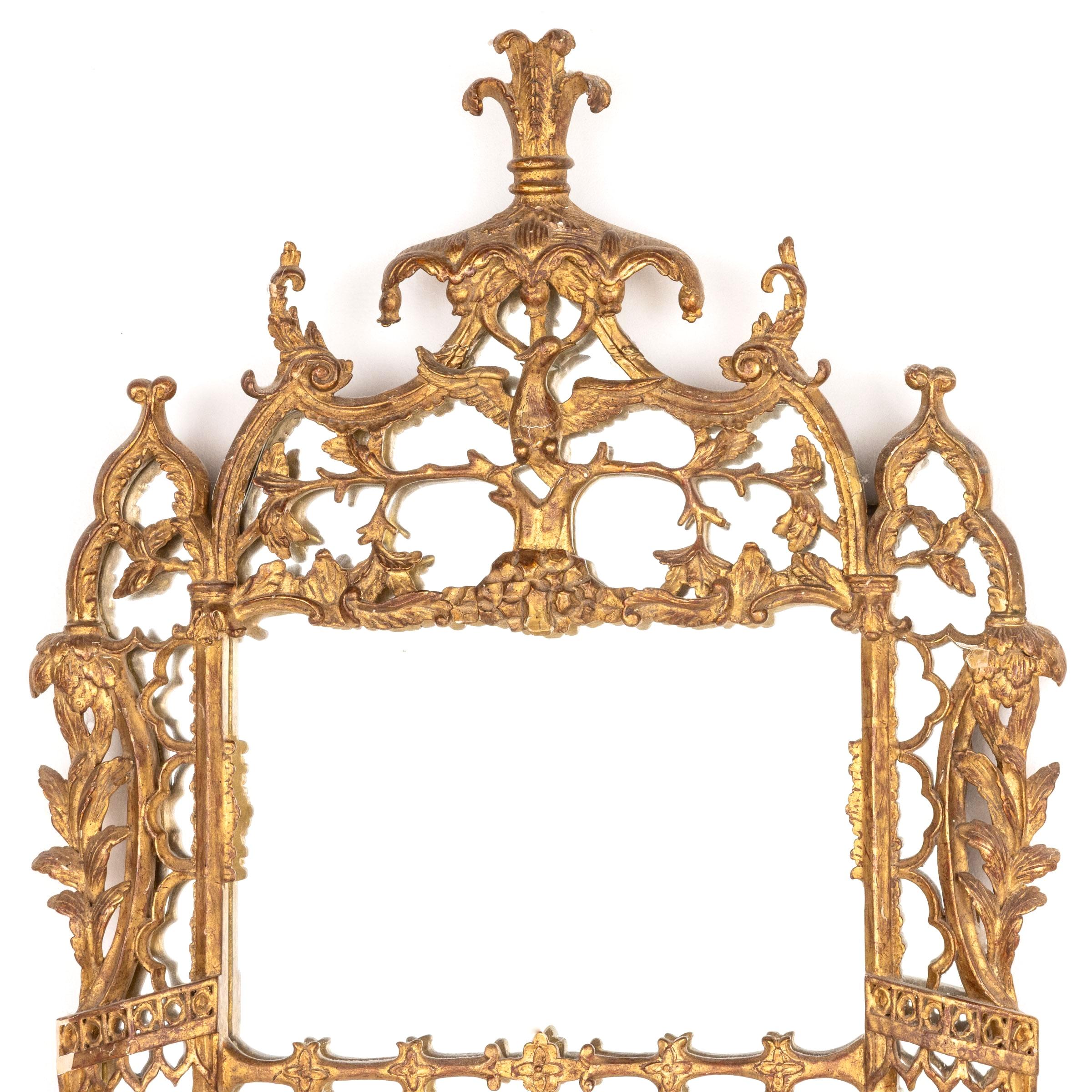 Miroir en bois doré de style George III richement détaillé. La plaque de miroir rectangulaire divisée est placée dans un cadre en bois doré sculpté de manière élaborée et présentant des motifs ajourés. L'entourage est orné de feuilles d'acanthe