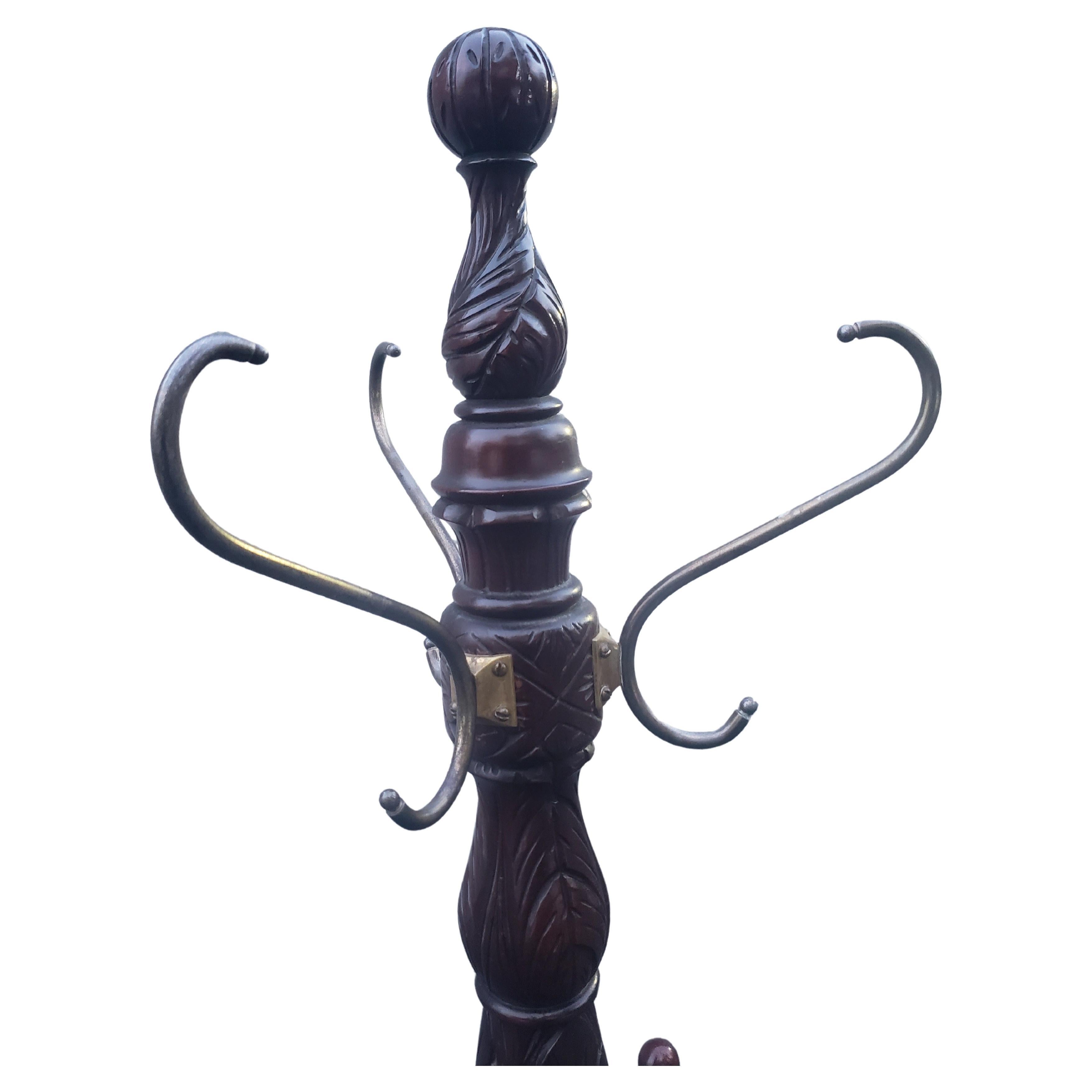 A beautiful George III style mahogany hand carved coat and hat rack with Tripod paw feet. Features 3 brass scrolled hooks and six wooden pegs. Measures 22