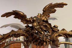 George III Style Heavily Carved Rococo Oval Giltwood Mirror with Eagle Crest