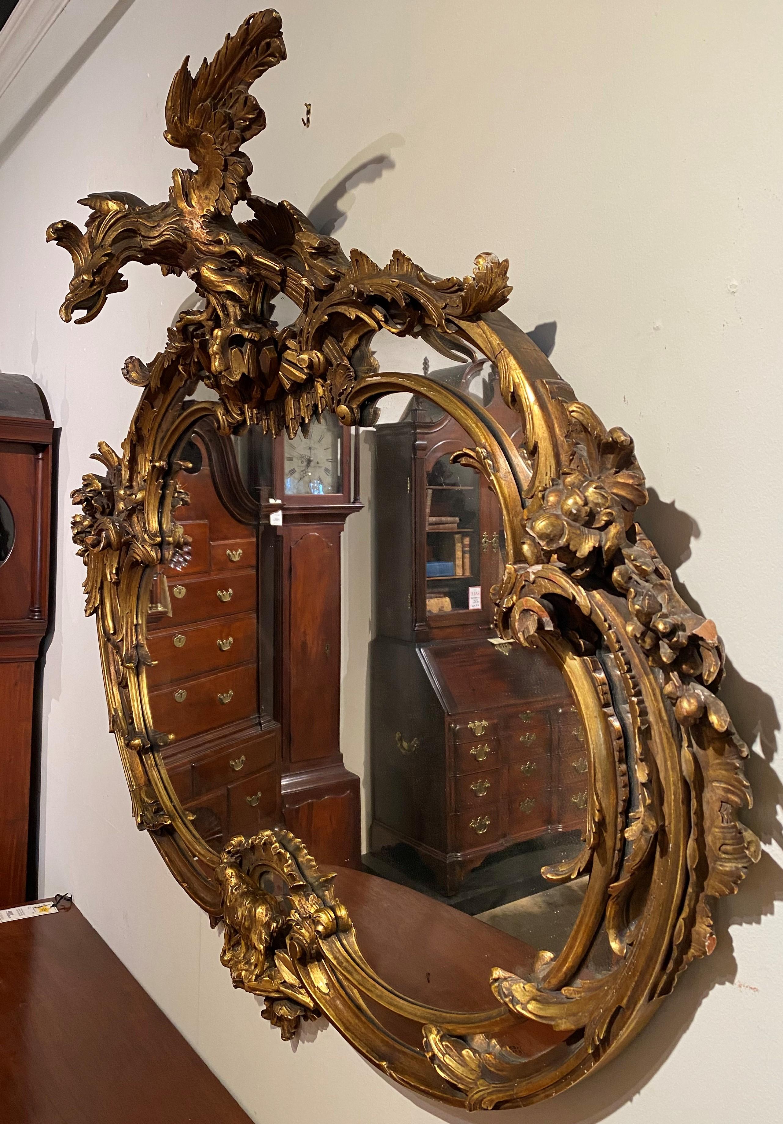 George III Style Heavily Carved Rococo Oval Giltwood Mirror with Eagle Crest For Sale 1