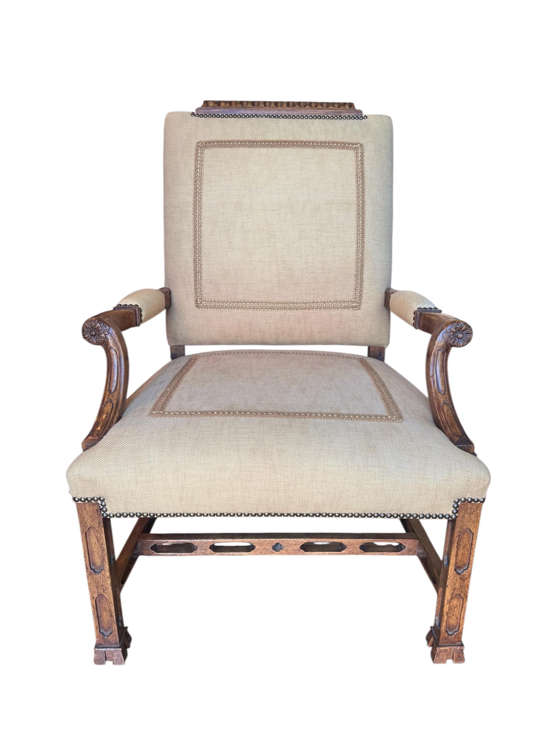Sillón de biblioteca estilo Jorge III. Marco de madera tallada y tapizado en lino beige con un ribete decorativo de seda. Acentuado con brazos de cuero tostado y cabezas de clavos de latón antiguo. Una silla muy cómoda, perfecta para leer. 

Lo