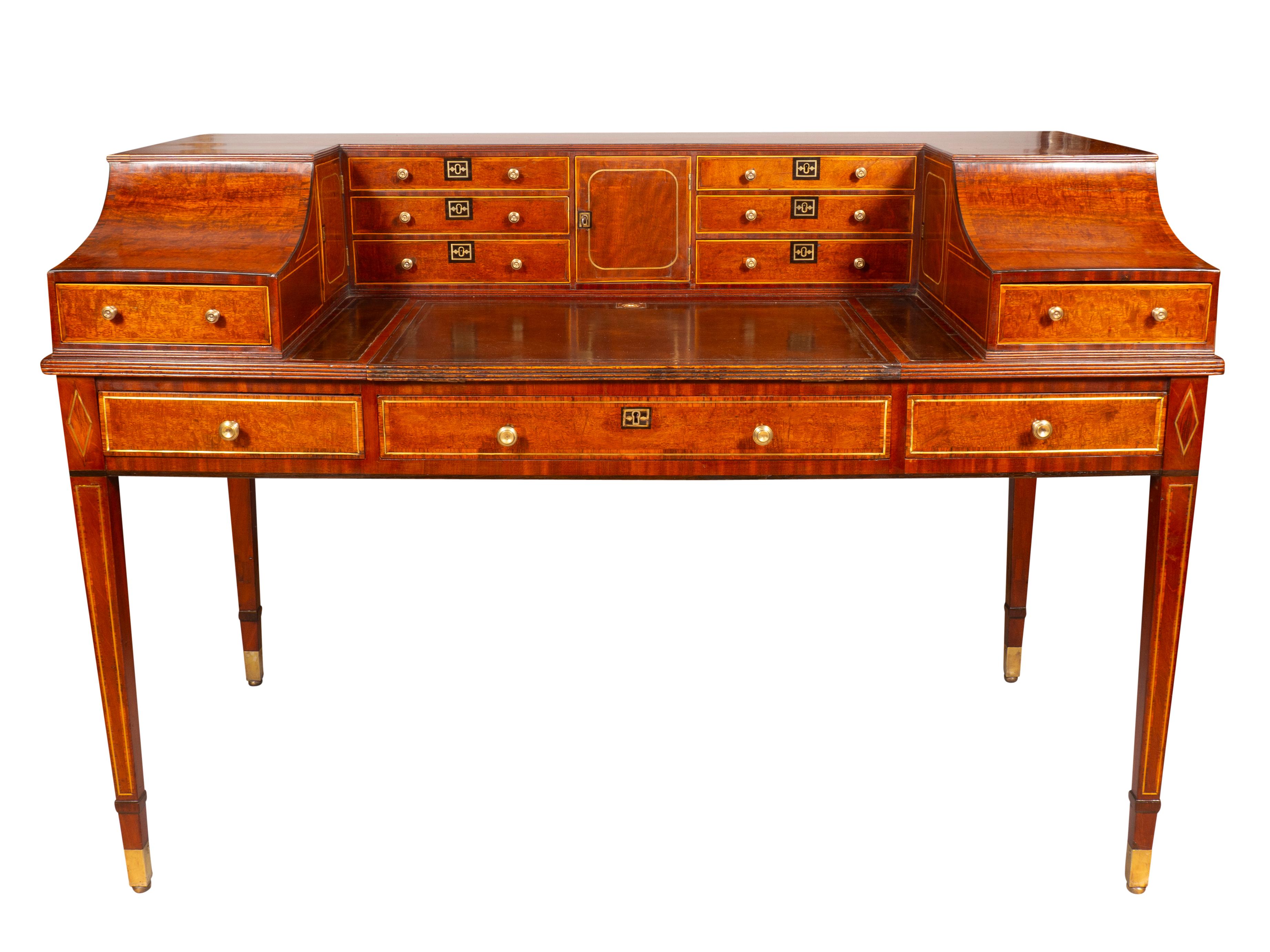Rectangular top with central leather liner hinged writing surface surrounded by drawers and doors. The back finished Frieze drawers all with brass inlays. Raised on square tapered legs with brass feet. Ex Hyde Park Antiques. NYC.