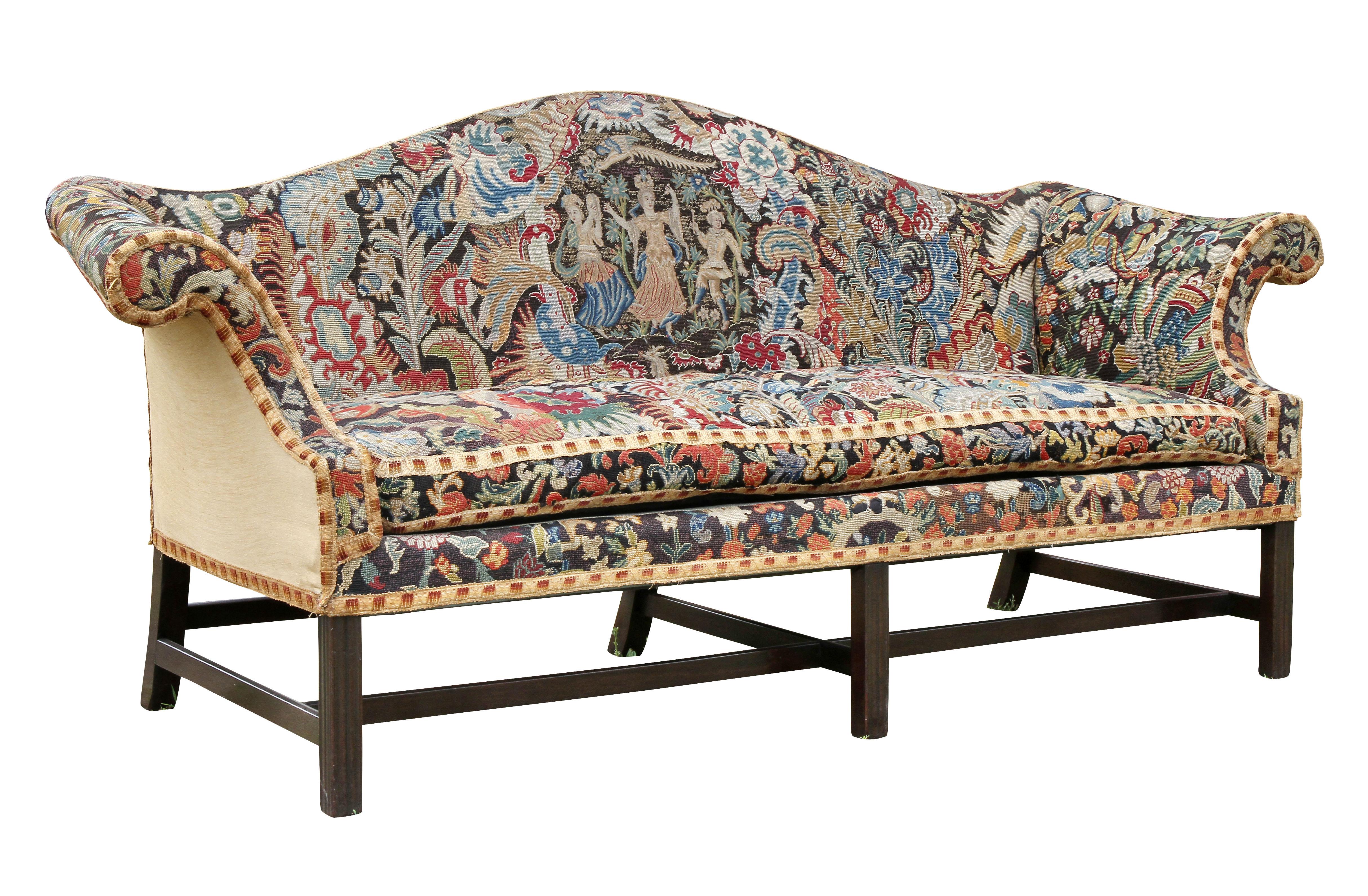 With a serpentine shaped back and straight seat with loose cushion, out scrolled arms, raised on square section legs with stretchers. A Classic form with colorful hand done needlepoint and petit point.