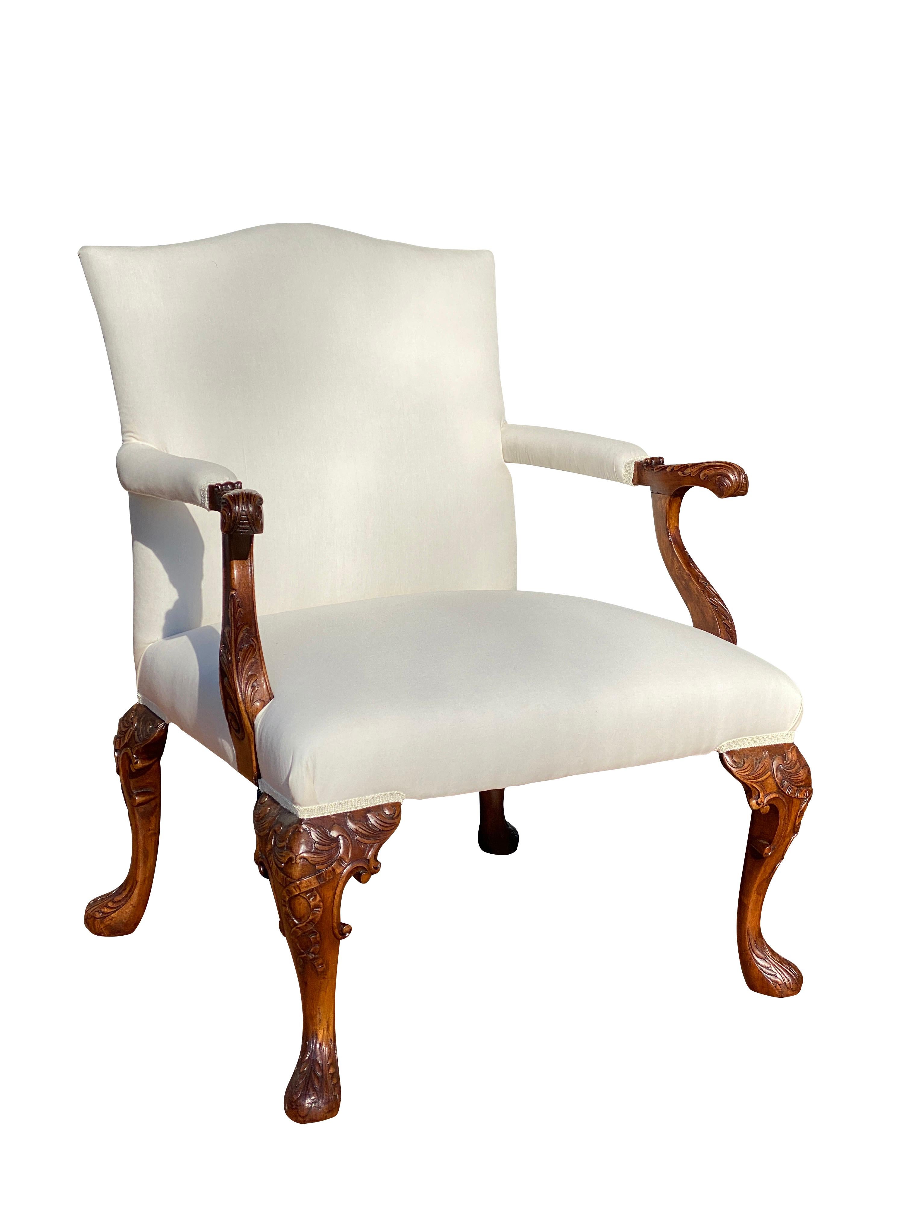 Serpentine upholstered back with carved scrolled arms and upholstered seat raised on carved cabriole legs and pad feet.