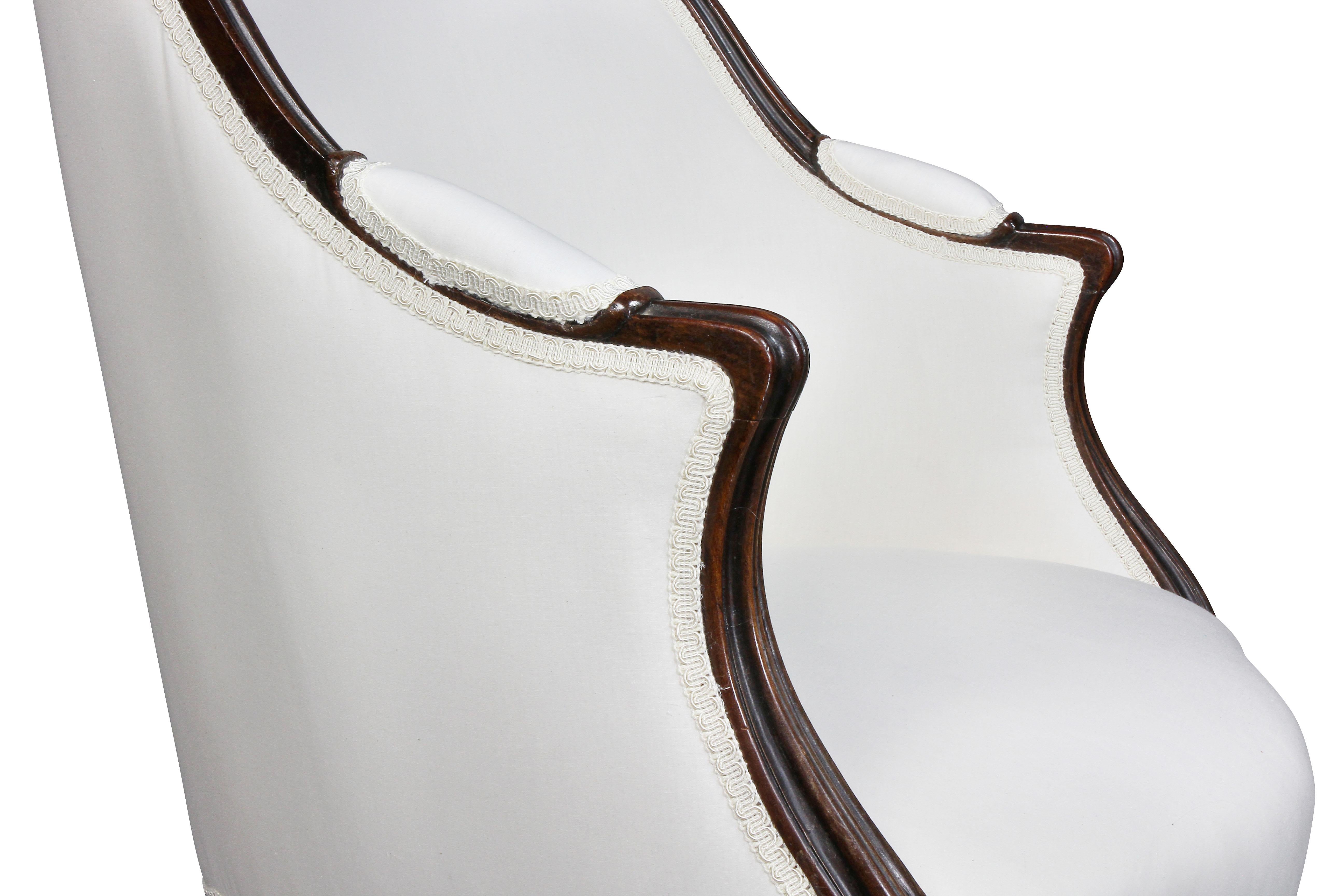 With arched upholstered back set in a nicely molded and carved frame, serpentine upholstered seat, raised on French style cabriole legs. Provenance, Harvard Art Museums. Newly upholstered with muslin.