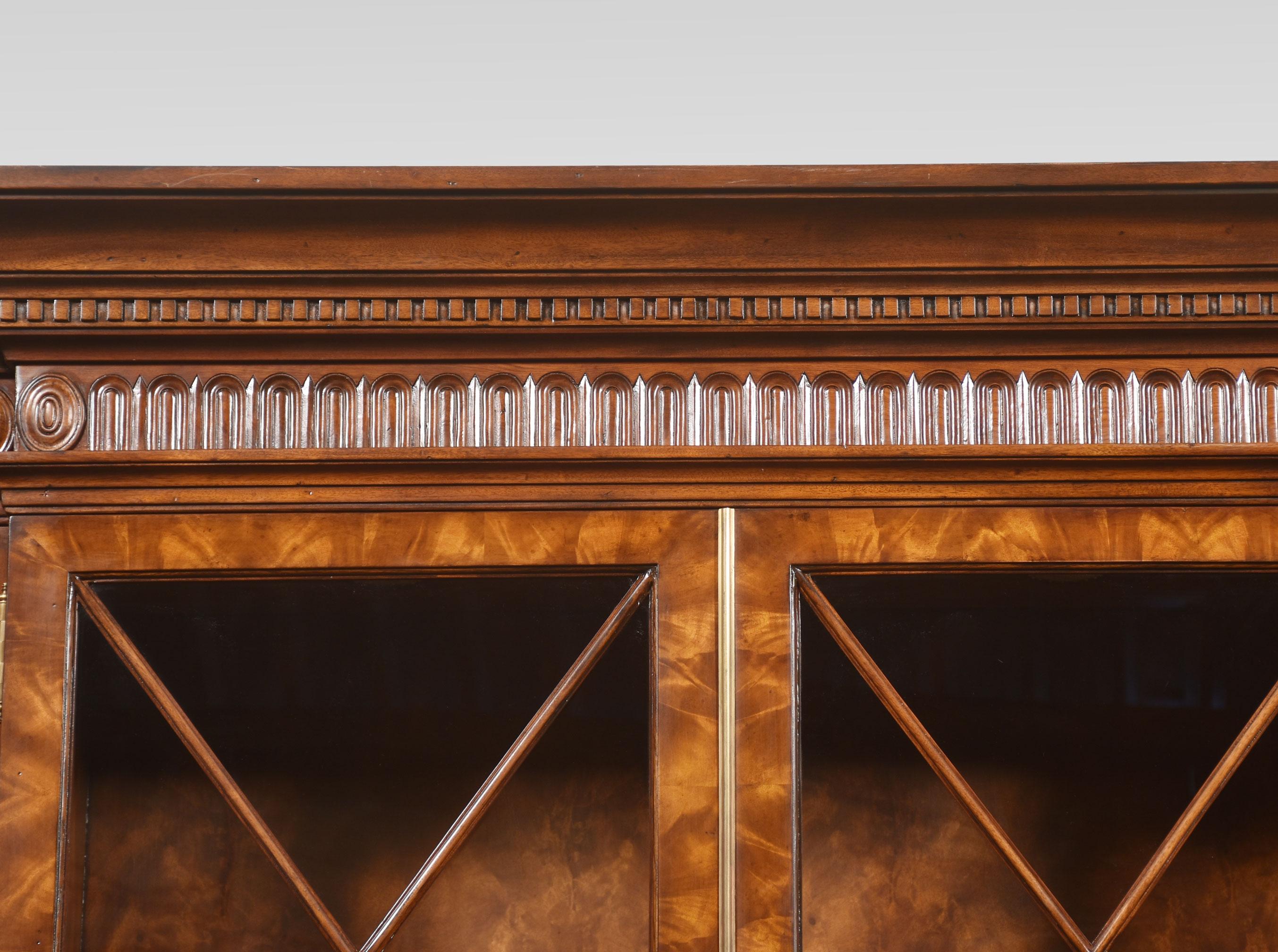 Großes Bücherregal aus Mahagoni im George-III-Stil, vor dem vorspringendes geschnitztes Gesims über vier großen, gut geformten, astragal glasierten Türen, die sich öffnen und ein verstellbares Regal öffnen lassen. Der Sockel ist mit einem Paar