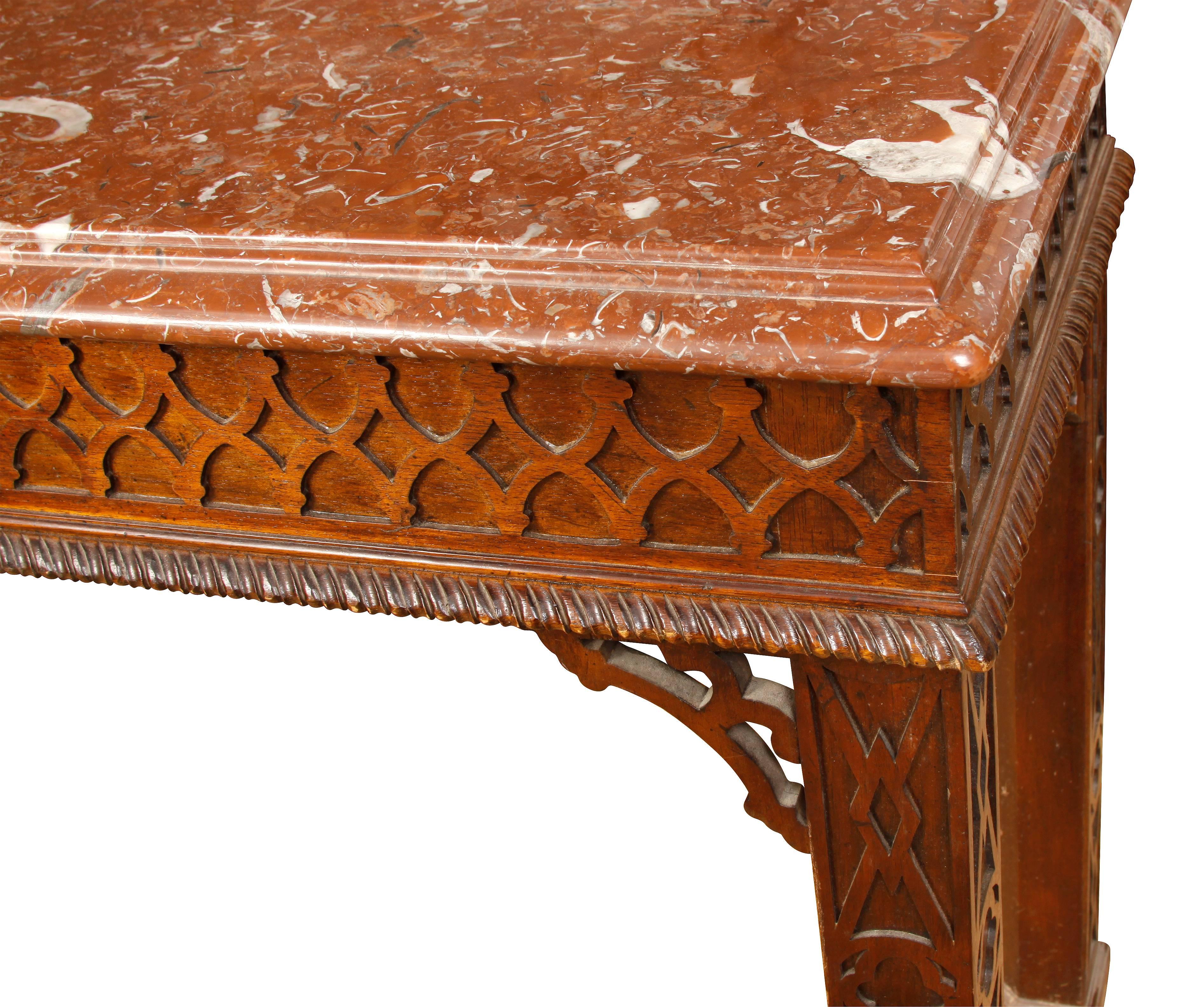 Table console de style George III en acajou avec des sculptures en relief et un plateau en marbre.