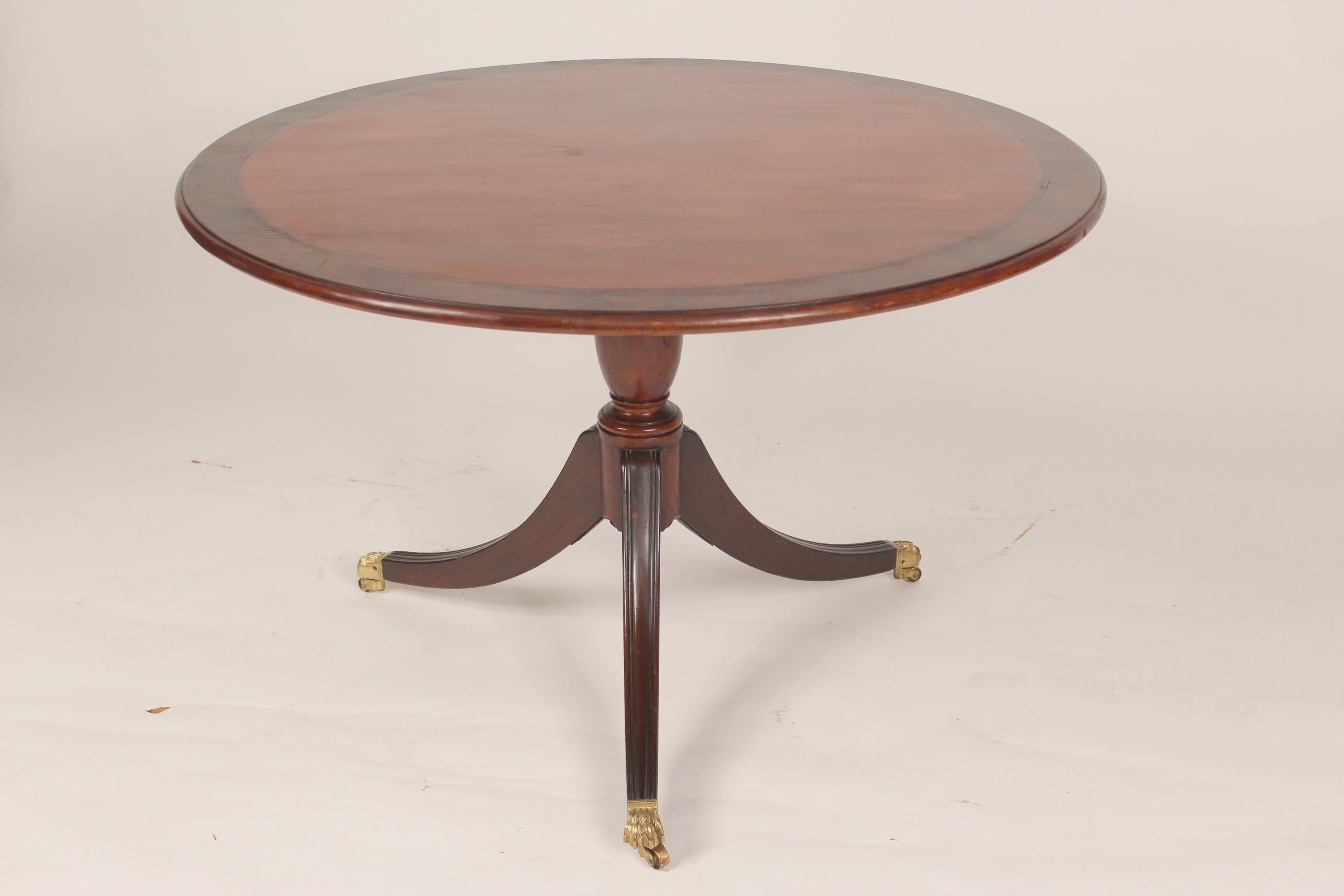 George III style mahogany breakfast / games / center table, circa 1920. This table has nicely figured mahogany with flame mahogany cross banding and brass lion paw feet.