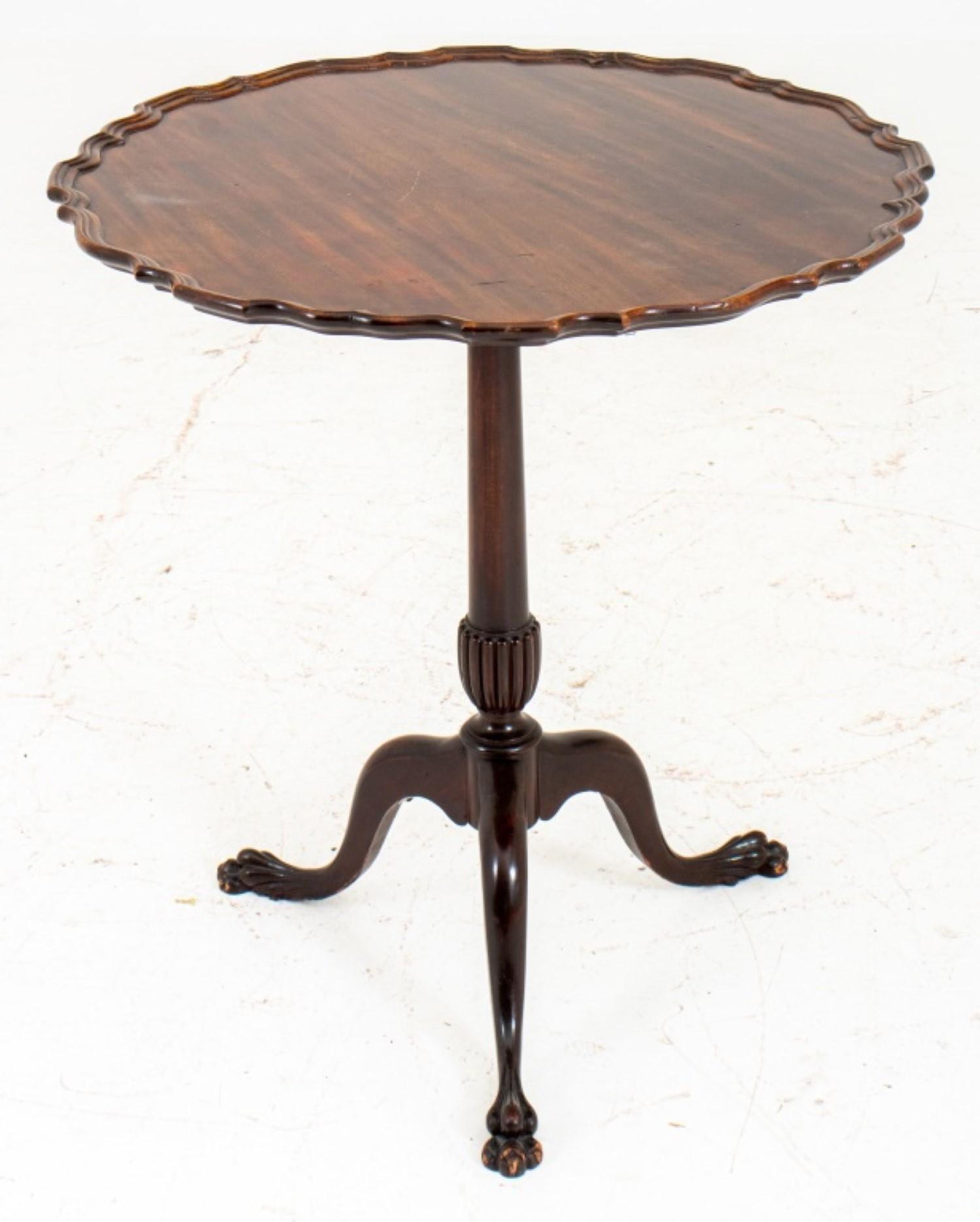  George III Style mahogany piecrust tripod table. Here are the details:

Style: George III
Material: Mahogany
Features:
Shaped circular top with a piecrust edge
Tilt mechanism
Faceted gadrooned shaft
Tri-pedal base
Elongated hairy paw