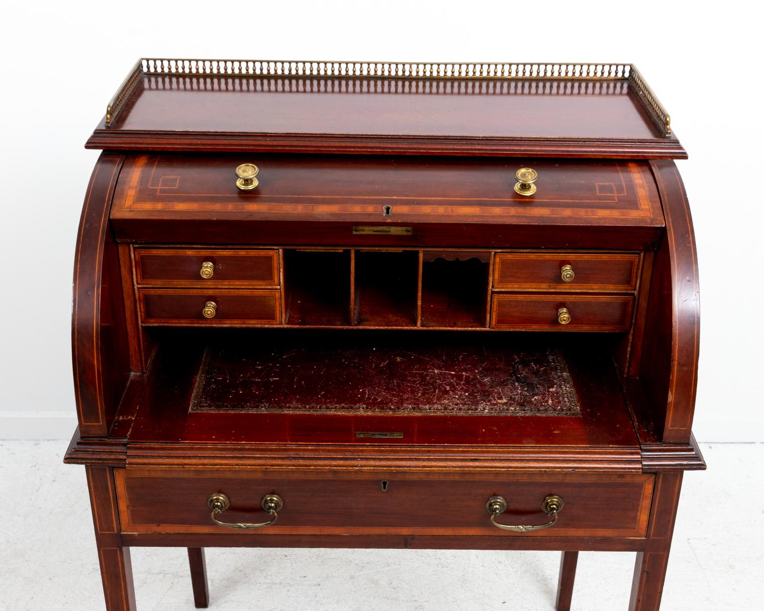 George III style roll top mahogany desk with various compartments and metal hardware, circa 1920s. Please note of wear consistent with age.
