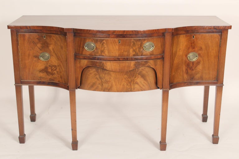 Antique George III style mahogany sideboard, circa 1900. With a serpentine front, nice quality flame mahogany used on front drawers and door, square tapered legs ending in spade feet, hand dovetailed drawer construction. Left side of sideboard has a