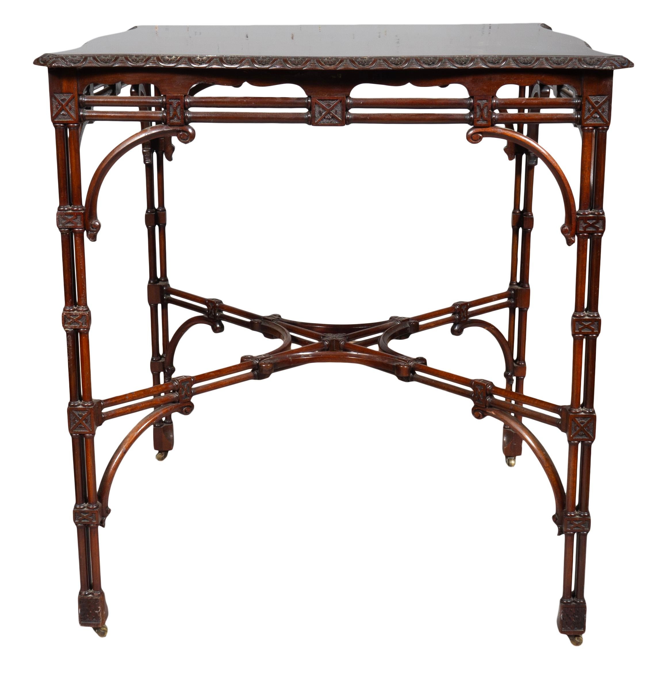 In the Chippendale style with shaped square top and cluster column frieze, legs and stretcher. Casters.