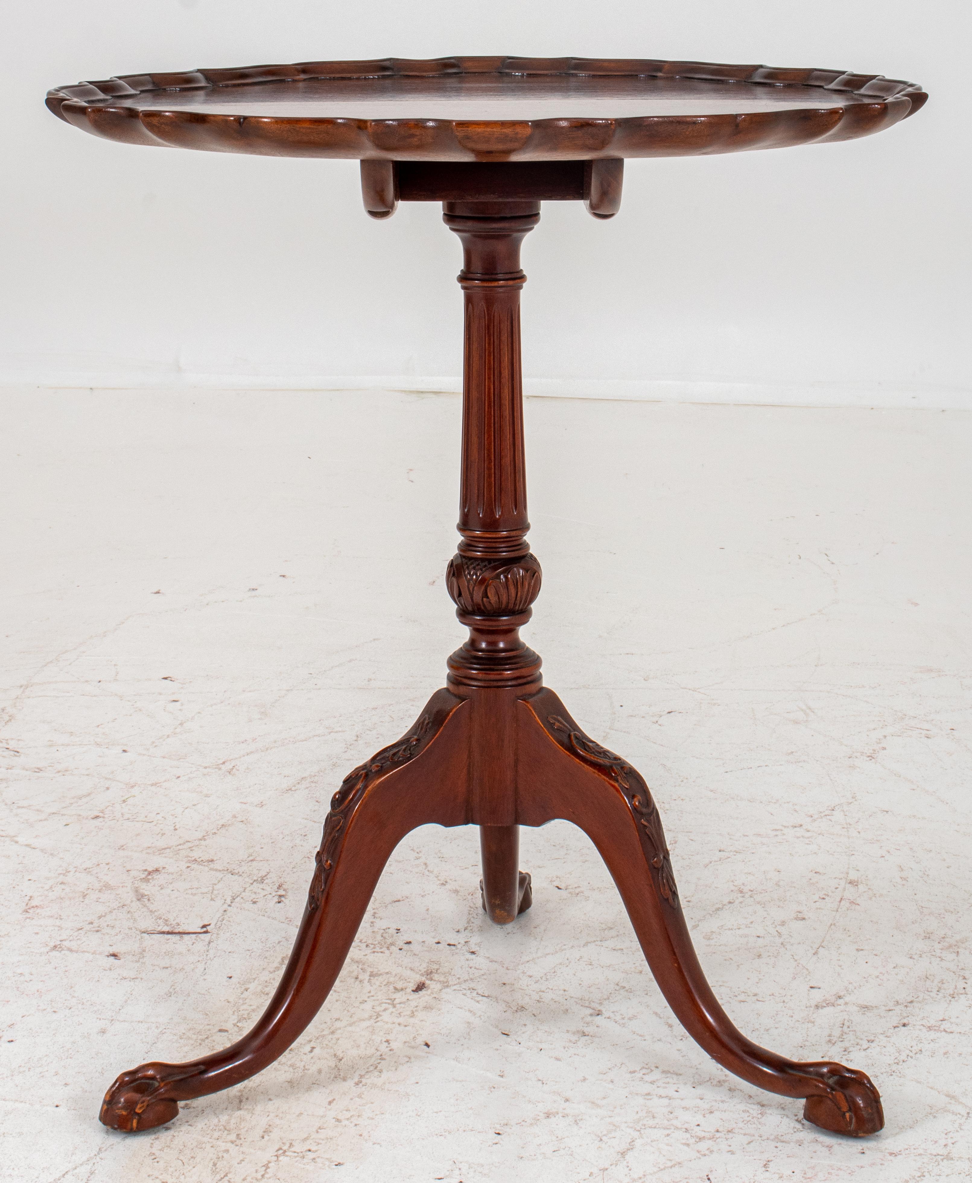 George III style Mahogany tilt-top tea table, round and with pie-crust edge,above a central pedestal on three legs engraved with rocailles, and on claw-and-ball feet. Measures: 28