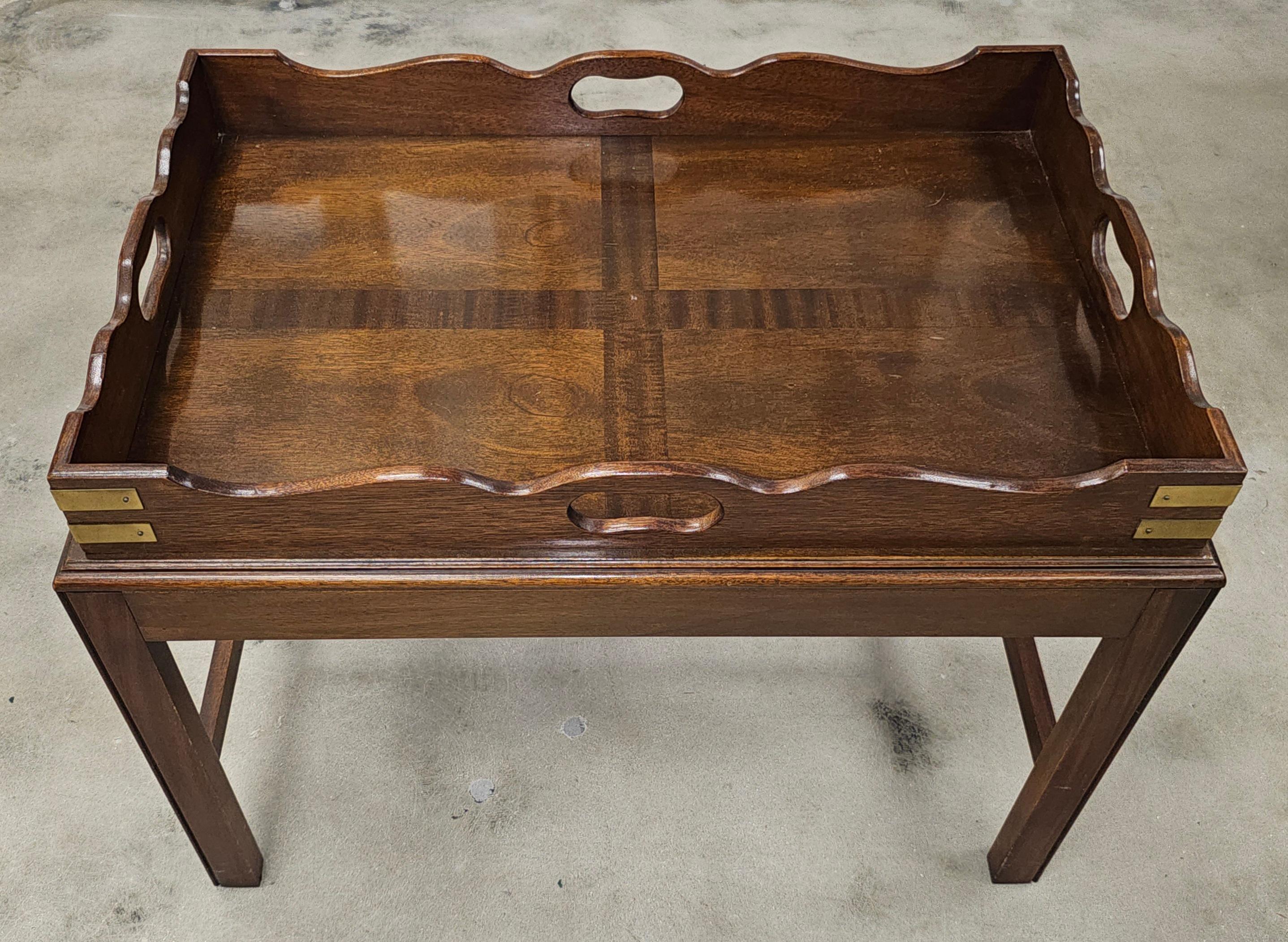 A Georgian Mahogany Rectangular Tray on Stand, which is a type of antique furniture that combines a serving tray with a stand. The tray is typically made of mahogany and has a rectangular shape with shaped sides and pierced carrying handles. The