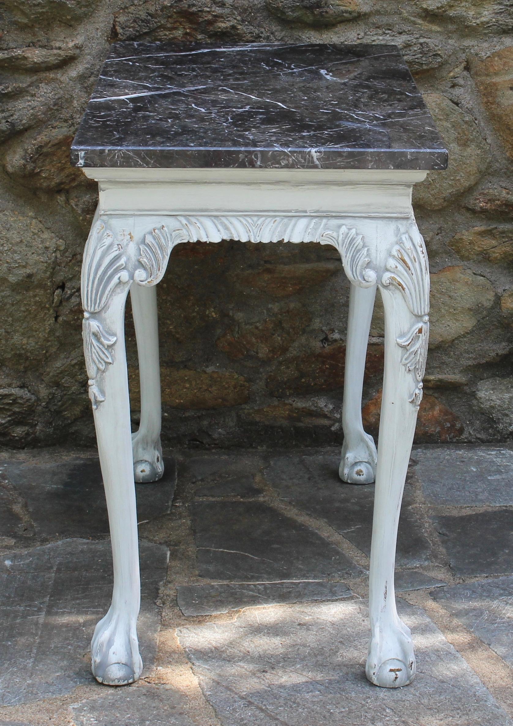 An elegant late 20th century. George III style console table beautifully carved and painted in a distressed gesso chalk finish with dark gray and white veined marble top.