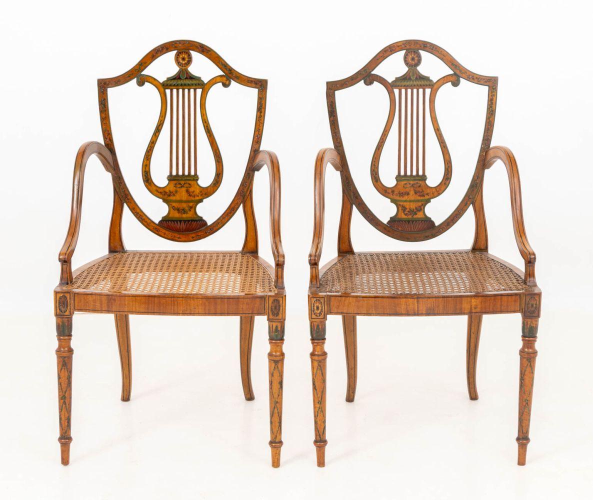 Paire de chaises à accoudoirs en bois satiné décoré et peint de style George III, chacune avec un dossier en forme de lyre et une assise en panneaux de canne. 37