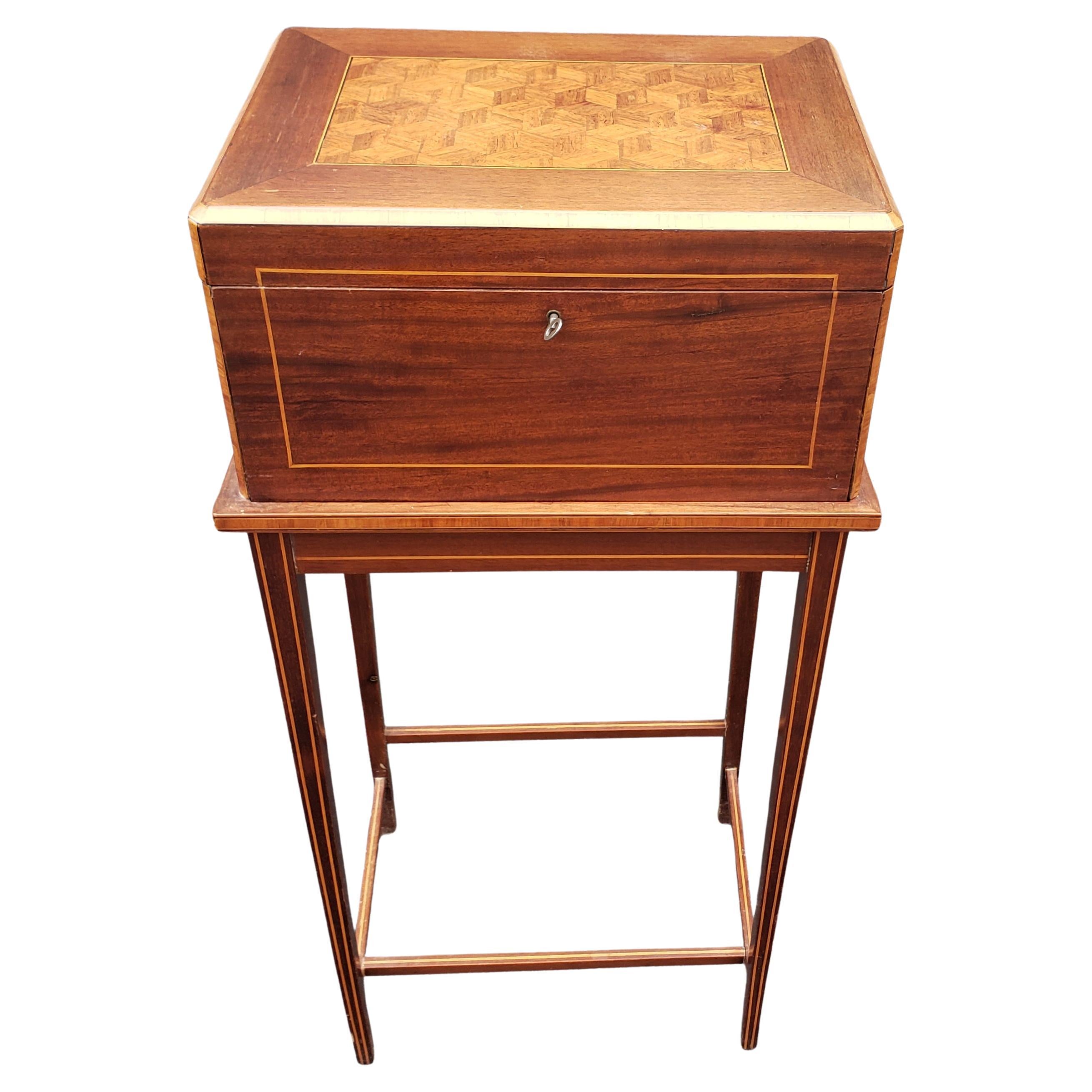 In stile George III, intarsi in legno di raso e intarsio di mogano, cassettiera con vassoio estraibile e serratura funzionale in ottime condizioni. Dispone di 2 cassetti e di un vassoio portaoggetti superiore, uno specchio smussato. Presenti i