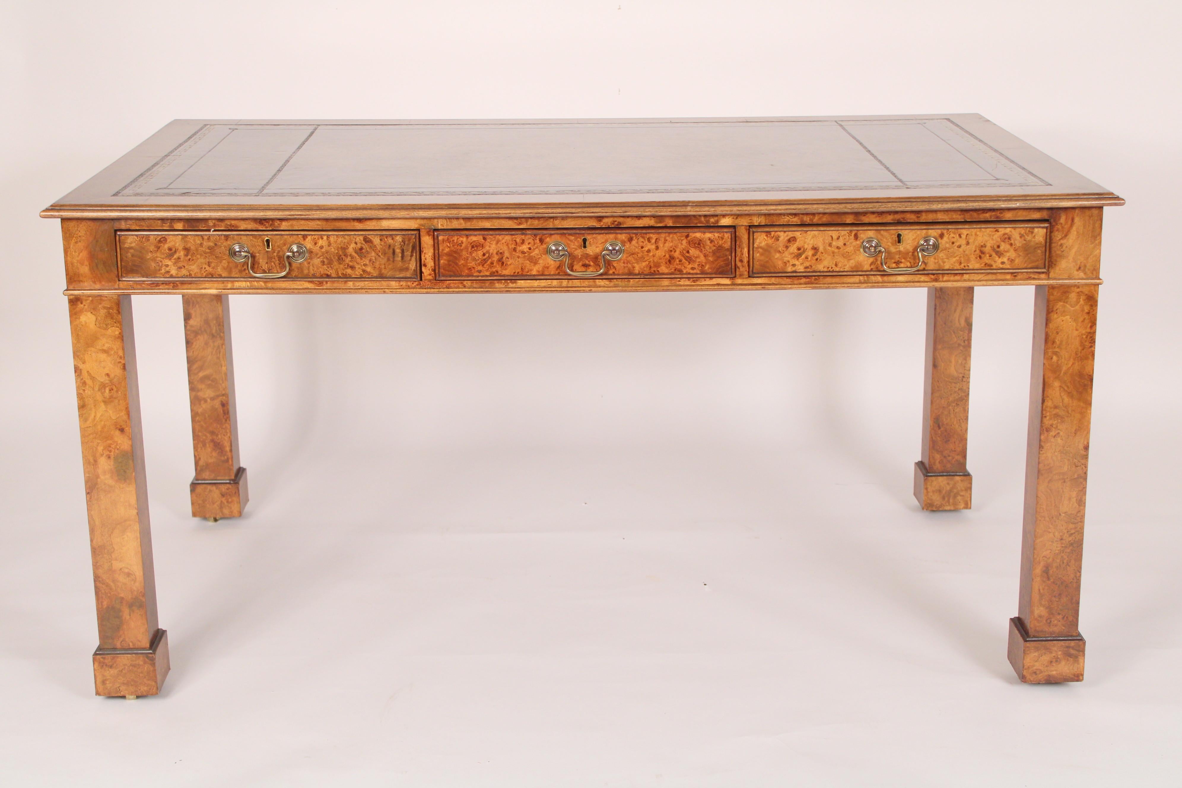 George III style burl elm partners writing table, late 20th century. With a gilt embossed tooled leather top, 3 frieze drawers with brass hardware on each side of desk, resting on square marlborough legs with block feet. Knee clearance 24.75