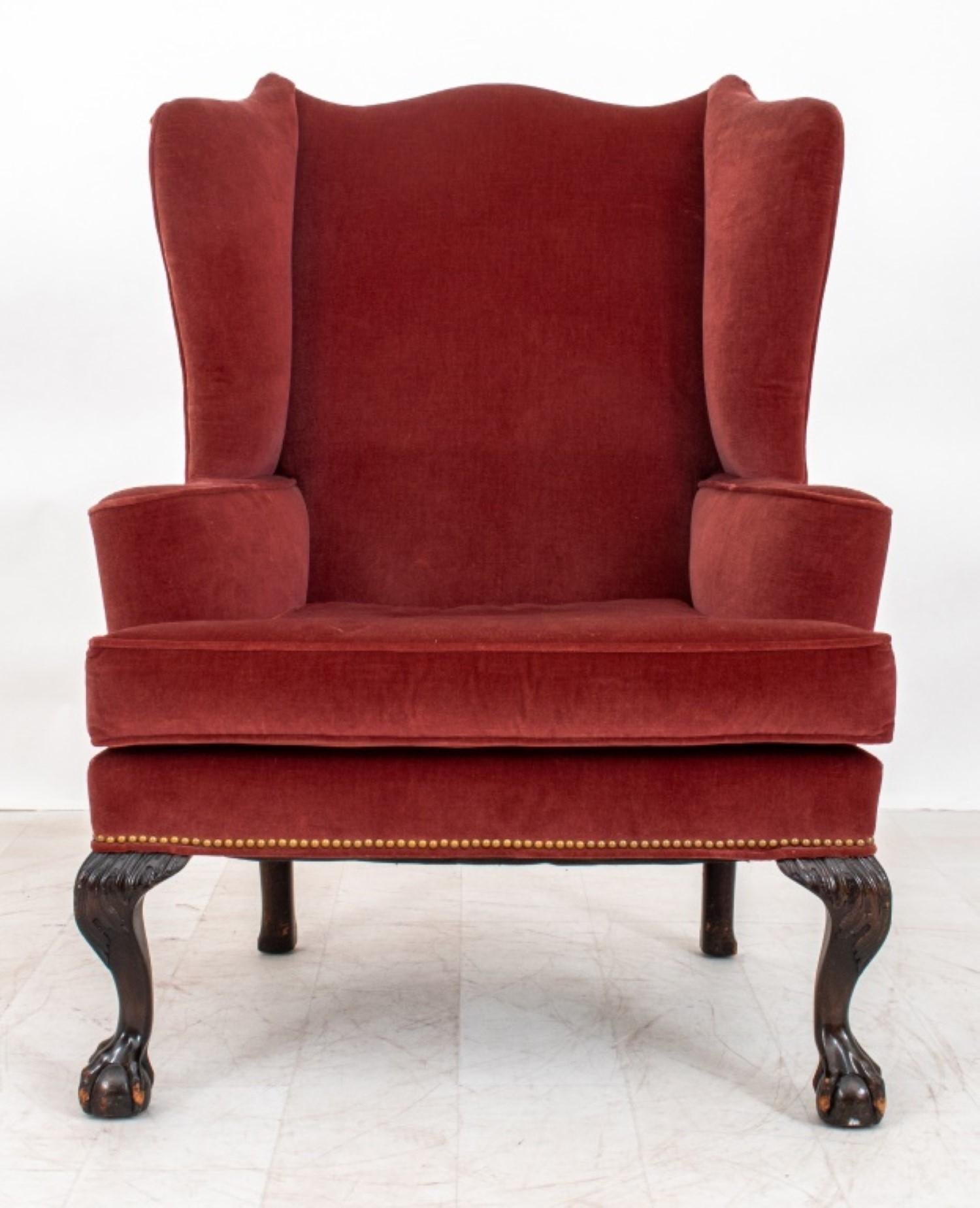 The George III style rose velvet upholstered wing chair stands on heavily carved acanthus claw and ball feet. It dates back to the 19th century or later. 

Dealer: S138XX