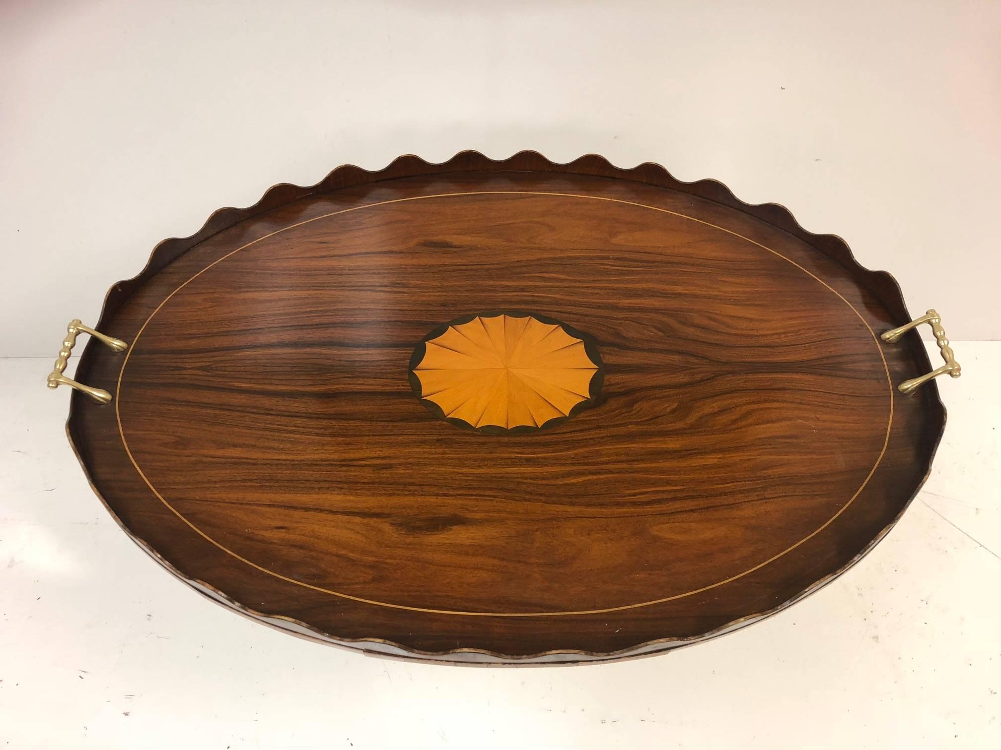George III style rosewood and inlay serving tray. The tray has solid brass handles, satinwood inlay to the center and a scalloped edge.