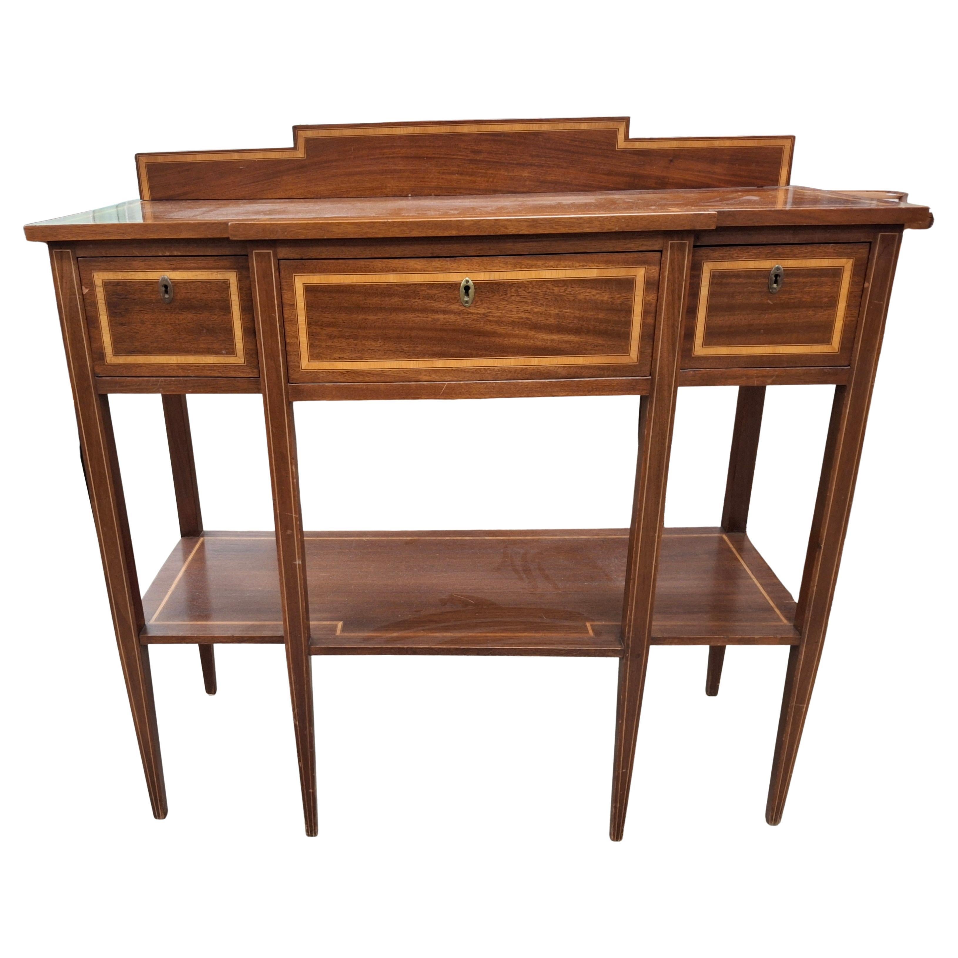 Excepcional mesa de servir de caoba con incrustaciones de madera satinada estilo Jorge III.
Mide 42