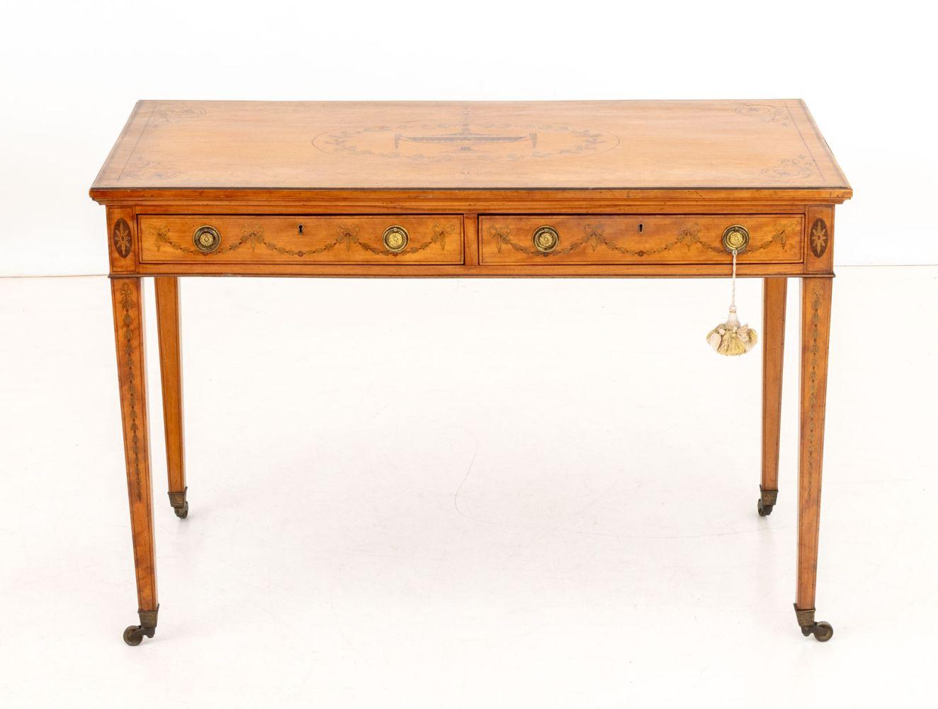 George III Style Satinwood Marquetry Console Table, inlaid urn decoration to the rectangular top above two short drawers on four tapered legs with casters. 
29.75