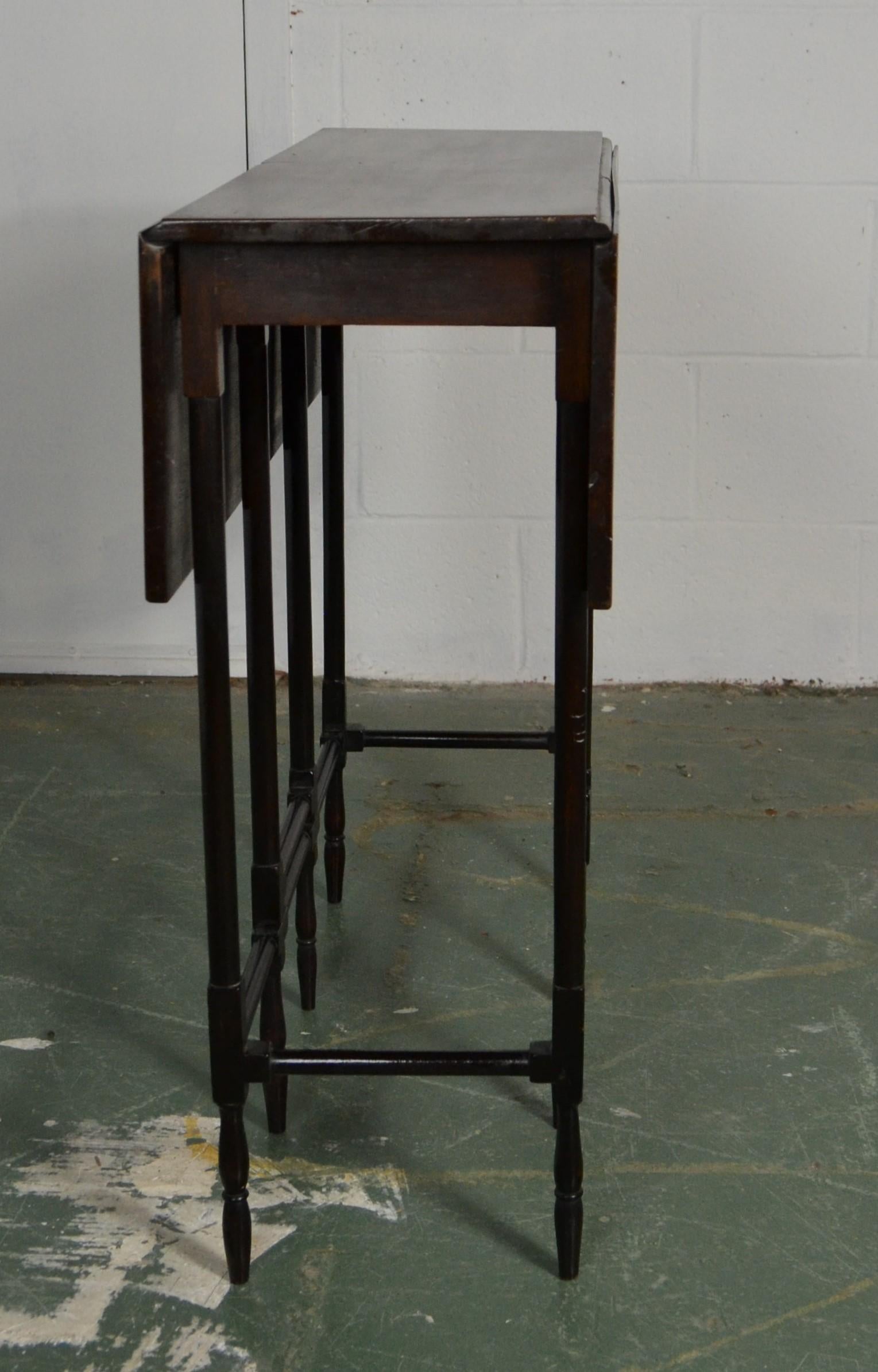 Georgian mahogany spider leg table having a rectangular top with two drop leaves that are supported by slender turned gate legs and are joined by carved and turned stretchers. Opened 27.75