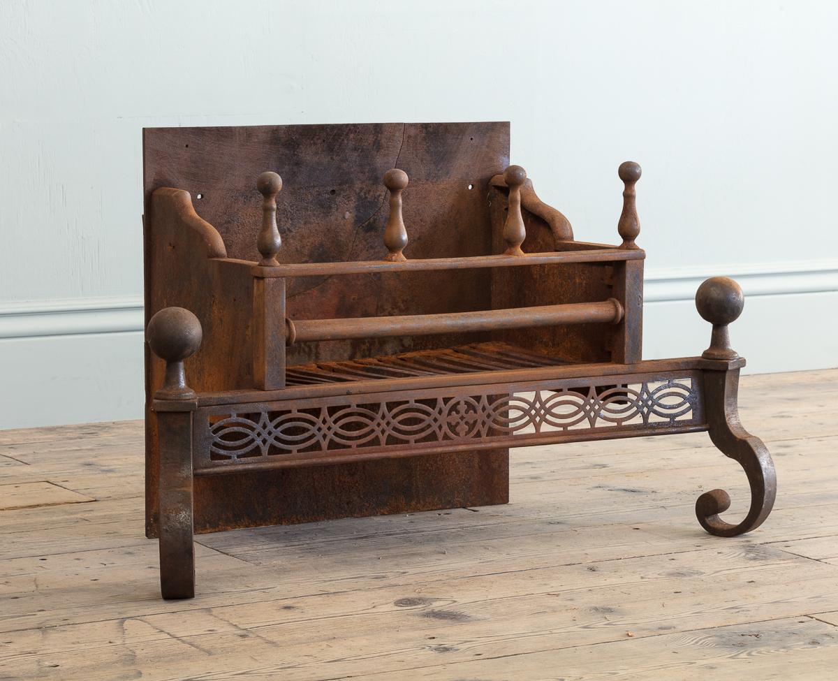 Die Brennfläche ist mit vier Kanonen verziert, die mit Kanonenkugeln gestoppt werden, über einem fein durchbrochenen Bund in der Art von Thomas Chippendale, flankiert von kantigen C-Schneckenbeinen, die von übergroßen Kugelknäufen gekrönt