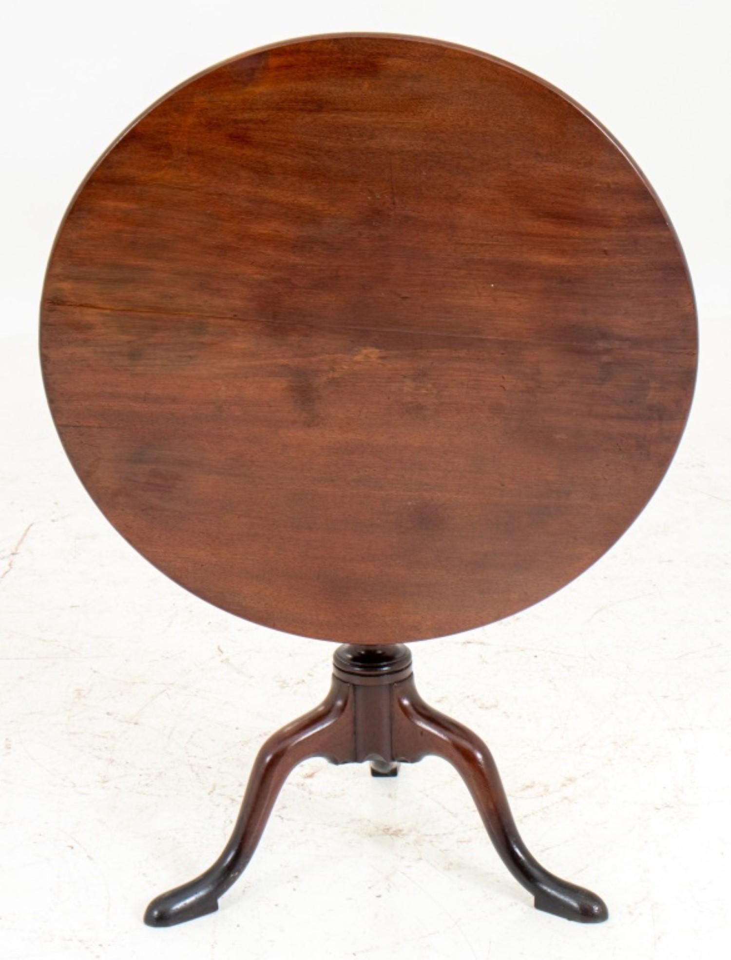 George III style tilt-top tripod table, with a circular top above a gadrooned vasiform support on a tripod base terminating in pad feet.

26 inches in height and 29 inches in diameter.