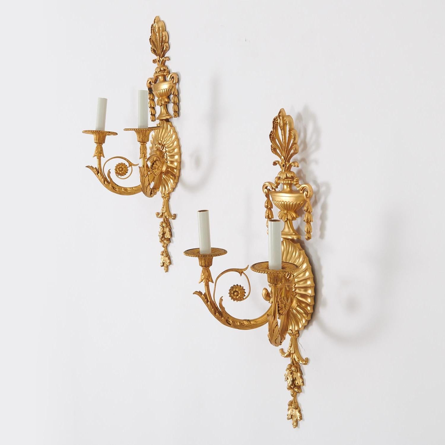 Each sconce with two arms issuing from a channeled oval backplate topped with an urn and plume finial, impressed manufacturer mark on reverse,

Maker: Edward F. Caldwell Co. (1851-1914)
Origin: American
Date: Early 20th century
Dimension: 23
