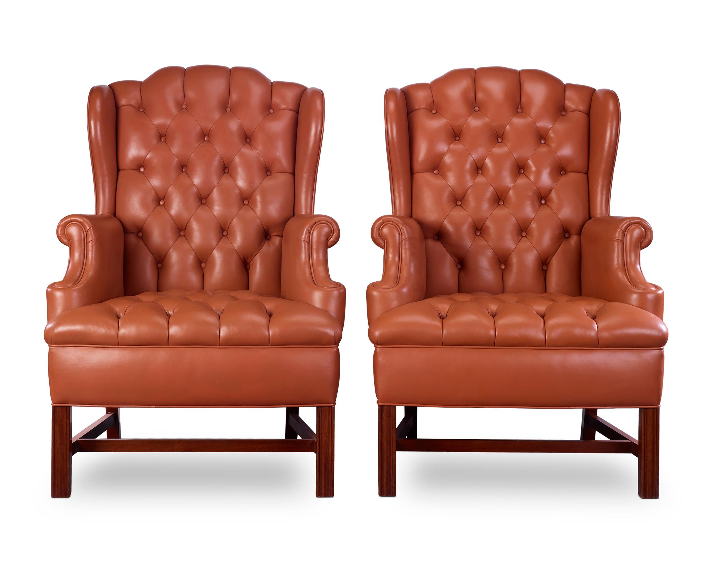 The ultimate in luxury, this pair of George III-style tufted leather chairs with matching ottomans provide comfort while maintaining aesthetic appeal. Beautifully proportioned and upholstered in handsome tobacco-colored leather, this set exudes all