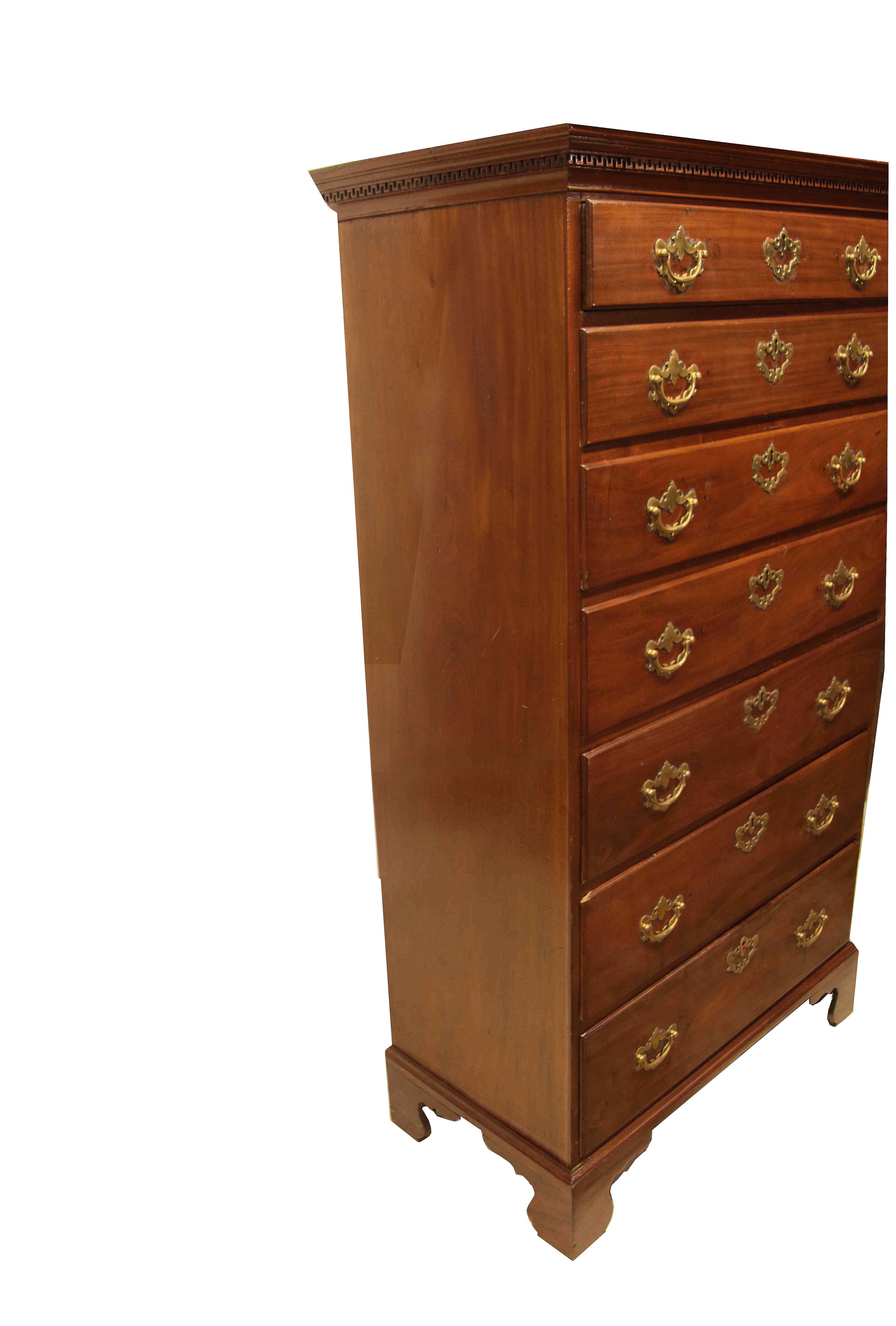 George III tall mahogany chest, with the original cove cornice featuring ''wall of Troy'' dentil molding, this above the seven graduated drawers with overlapping edges and oak secondary wood, the brass pulls and escutcheons are hand made in England