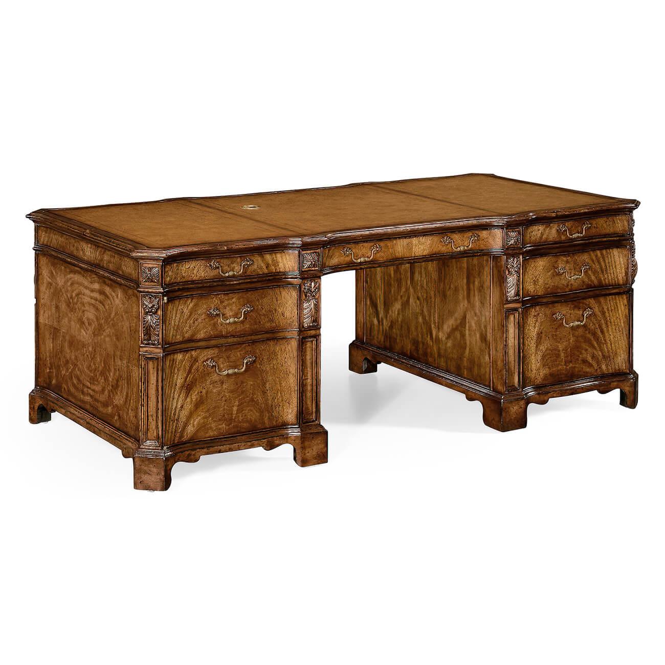 George III style walnut faux partners pedestal desk with oak secondary woods, with a tan inset leather top, cable management system and secret drawers. Having canted corners with carved acanthus elements, serpentine carved and molded edge, the