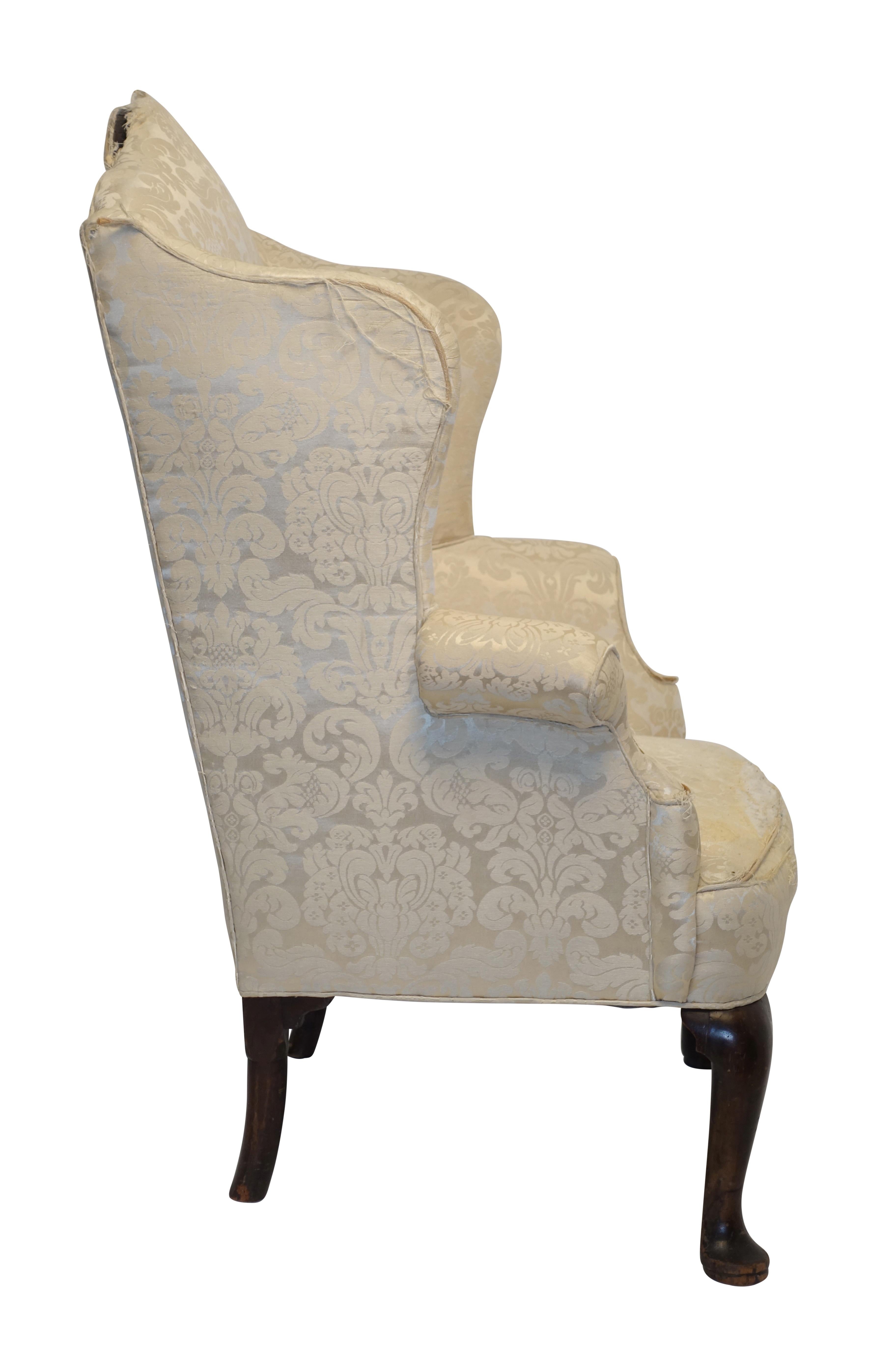An excellent example of a Georgian wingback armchair. Having shapely wings and arch top backrest with swooping arms, standing on a pair of Queen Anne legs with pad feet on the front and very typical round Georgian back legs. England, circa 1800.