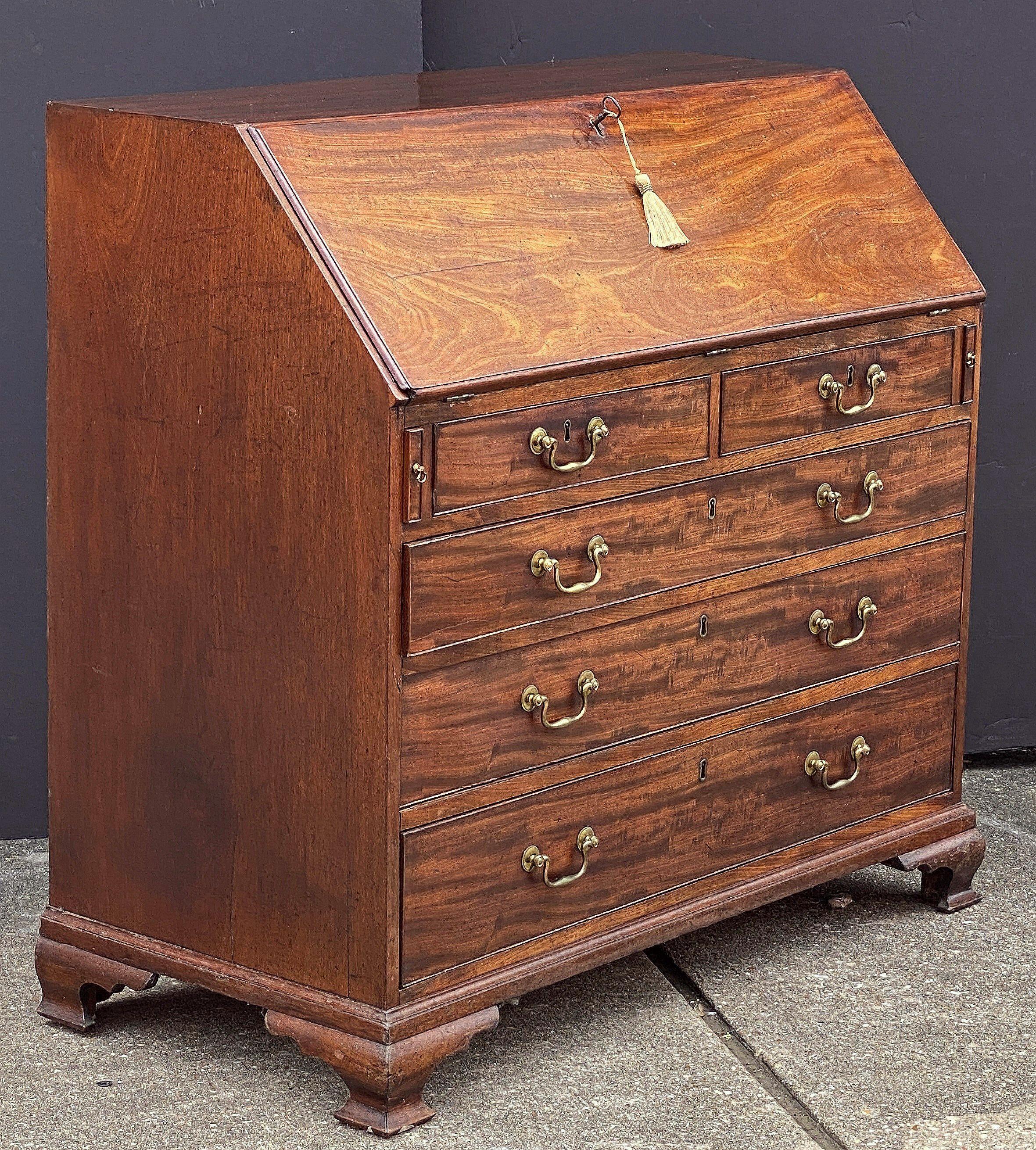 A fine George III slant top desk or bureau secretary chest of patinated mahogany, c.1770, in the Sheraton style.

An inlaid slant front drops to reveal a series of small drawers and document compartments, with beautifully inlaid decorative designs