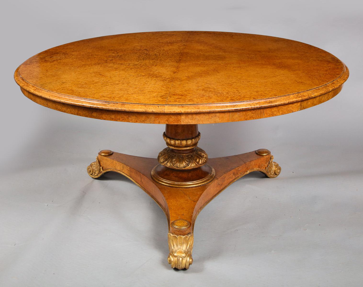A very fine George IV amboyna burl and giltwood center table attributed to T. & G. Seddon (formerly Morel and Seddon), circa 1835
The circular tilt-top with an ogee molded edge above a tapering turned, and acanthus-carved pedestal and a