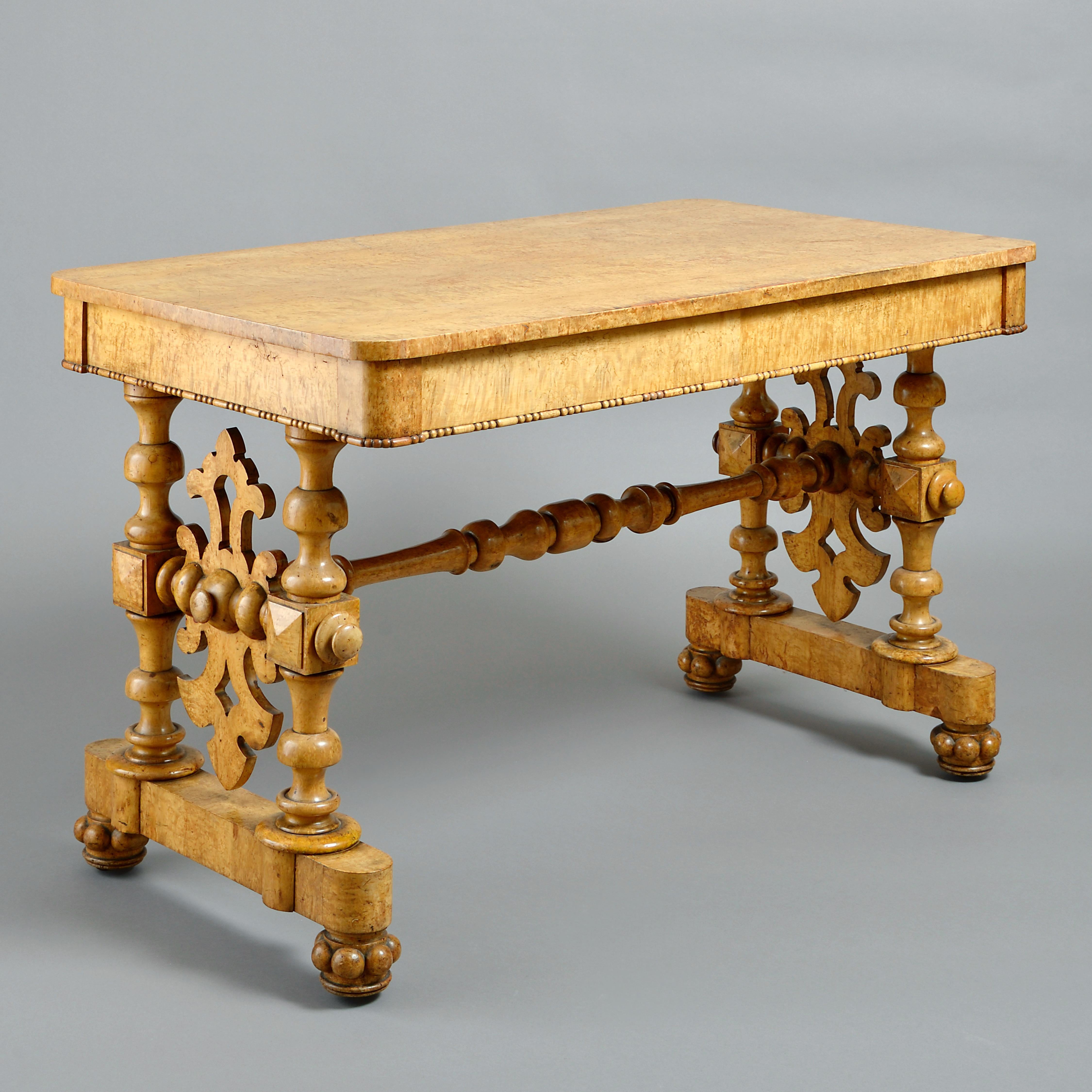 A GEORGE IV BURR MAPLE WRITING-TABLE IN THE MANNER OF RICHARD BRIDGENS, CIRCA 1830.

The frieze fitted with two mahogany-lined drawers. The feet with concealed castors.