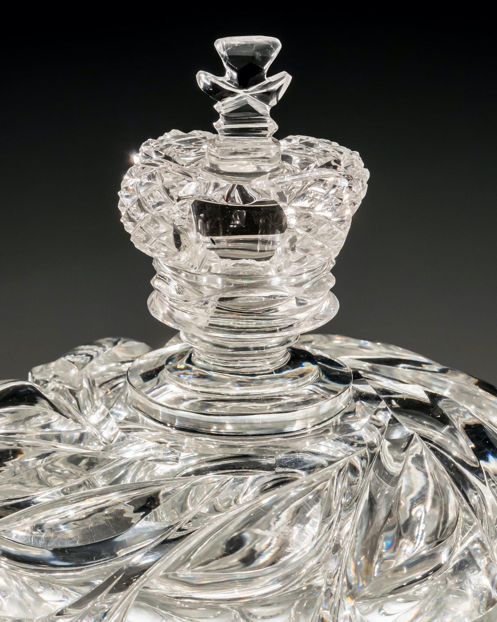 This magnificent cut glass urn stands on a Garter star cut foot, supporting the most unusual, deep scale and swirl cutting design. The corresponding lid unusually mounted with a crown finial, suggesting this was a special Royal commission.

Although