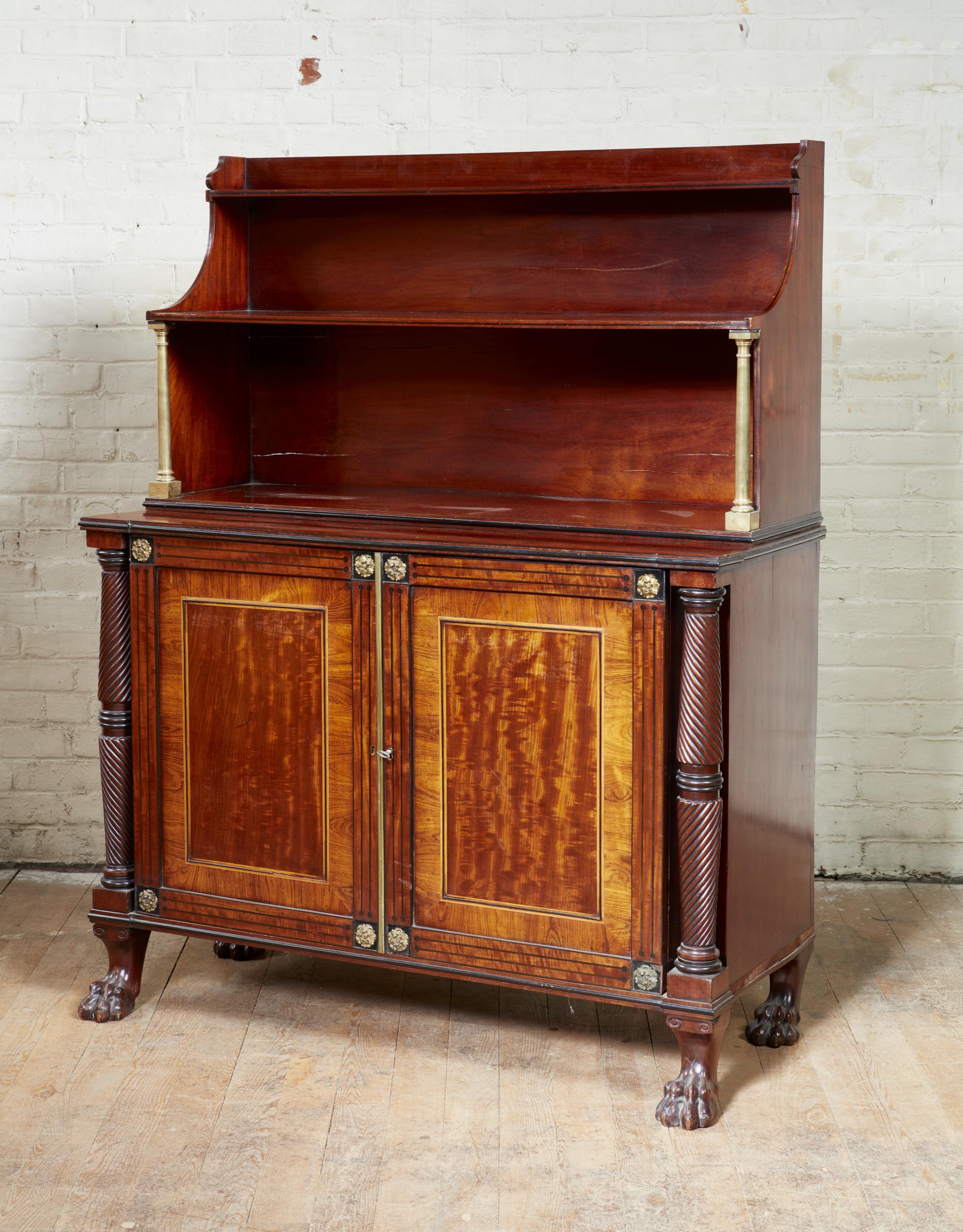 Very fine late Georgian inlaid mahogany and bronze mounted chiffonier, having three tier waterfall bookshelf top supported by bronze columns, over two gilt bronze mounted paneled doors with ebony and satinwood inlay, with kingwood banded beeswing
