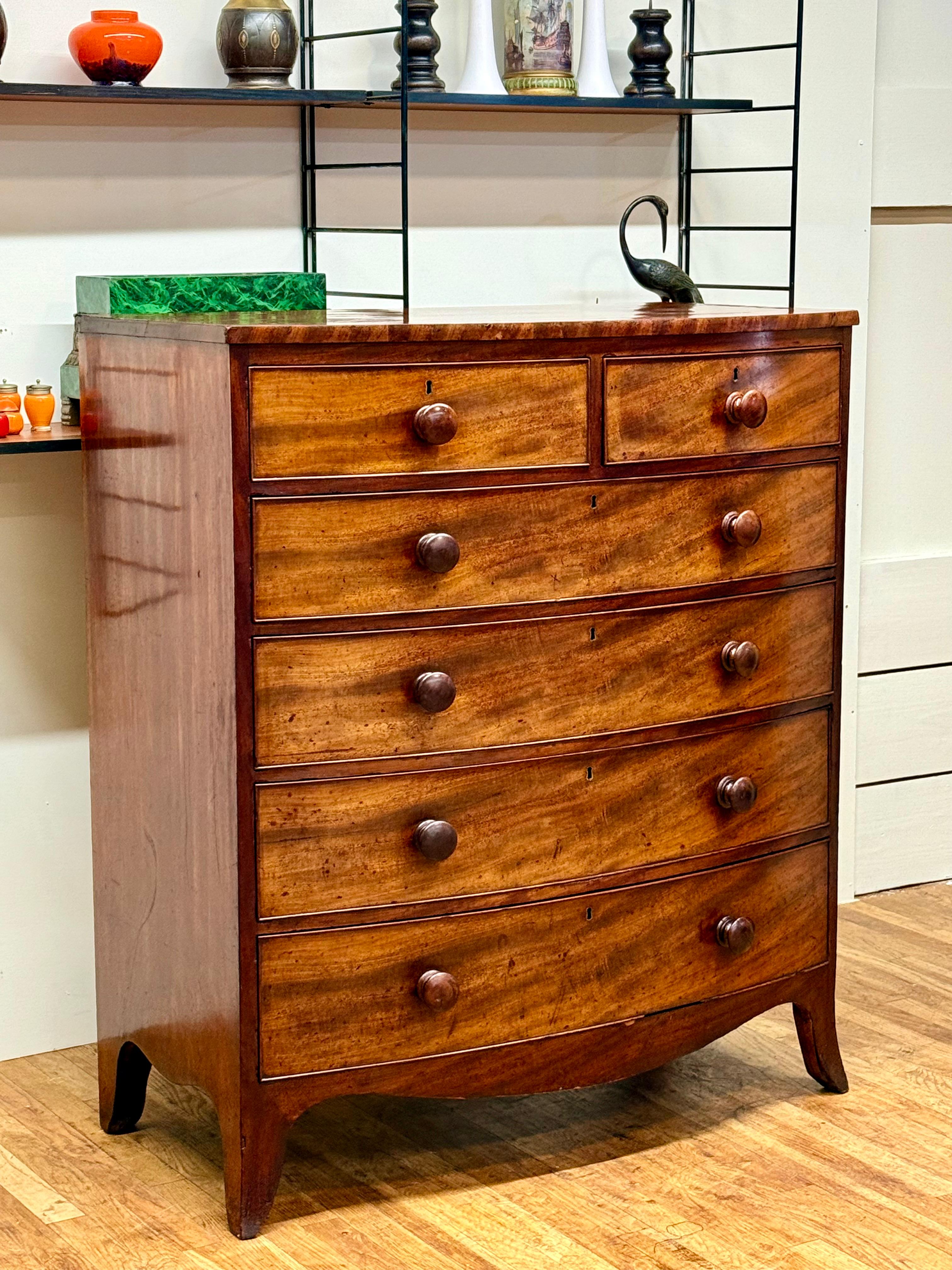 Discover a rare gem of Georgian craftsmanship with this stunning serpentine-front mahogany chest of drawers, dating to circa 1800. Predating the more common George IV pieces, this chest offers a glimpse into late 18th-century artistry, making it a