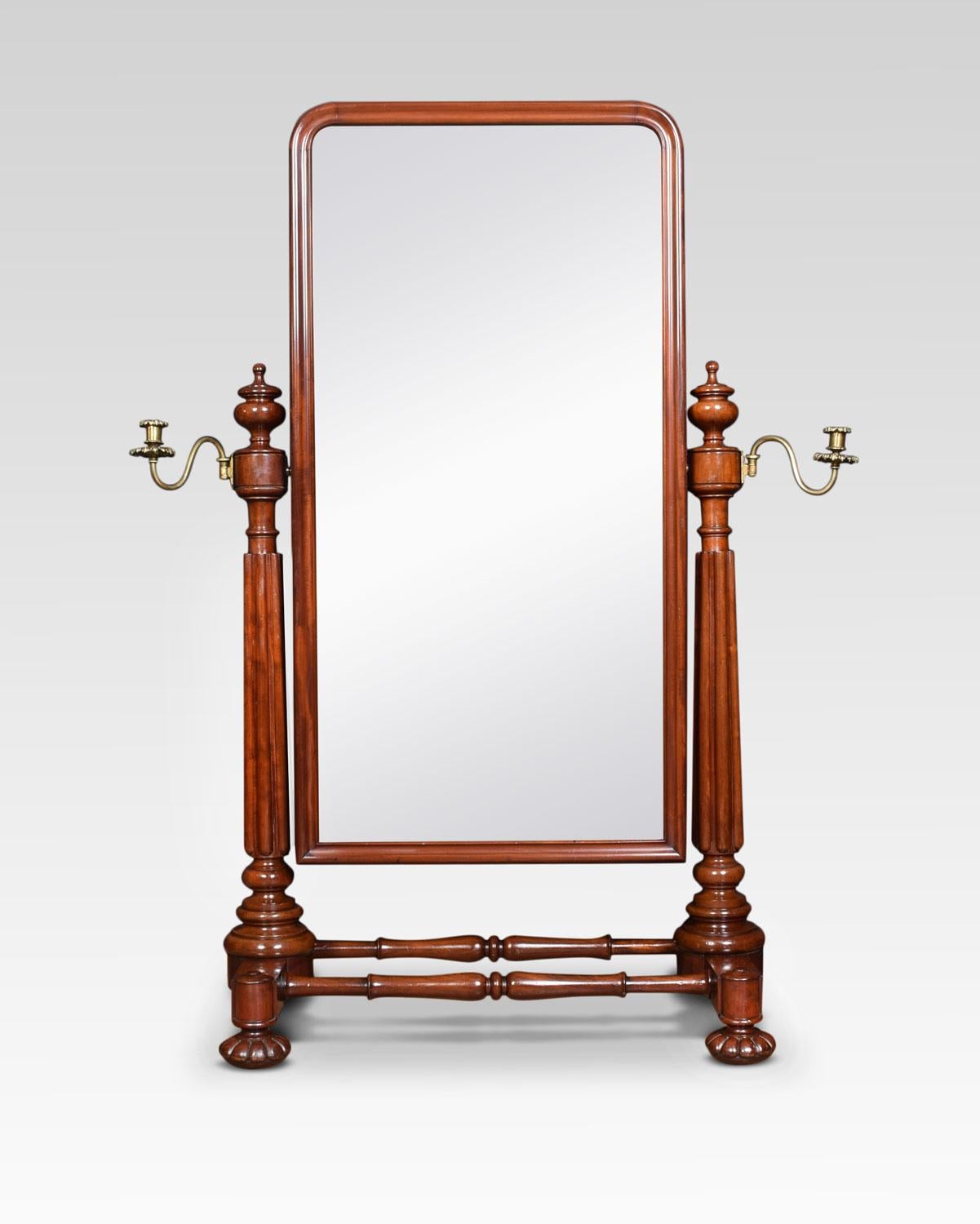 A large George IV mahogany cheval dressing mirror attributed to Gillows, the rectangular plate mirror with gilt brass adjustable candelabras on reeded turned end supports. All raised up on carved bun feet having recessed