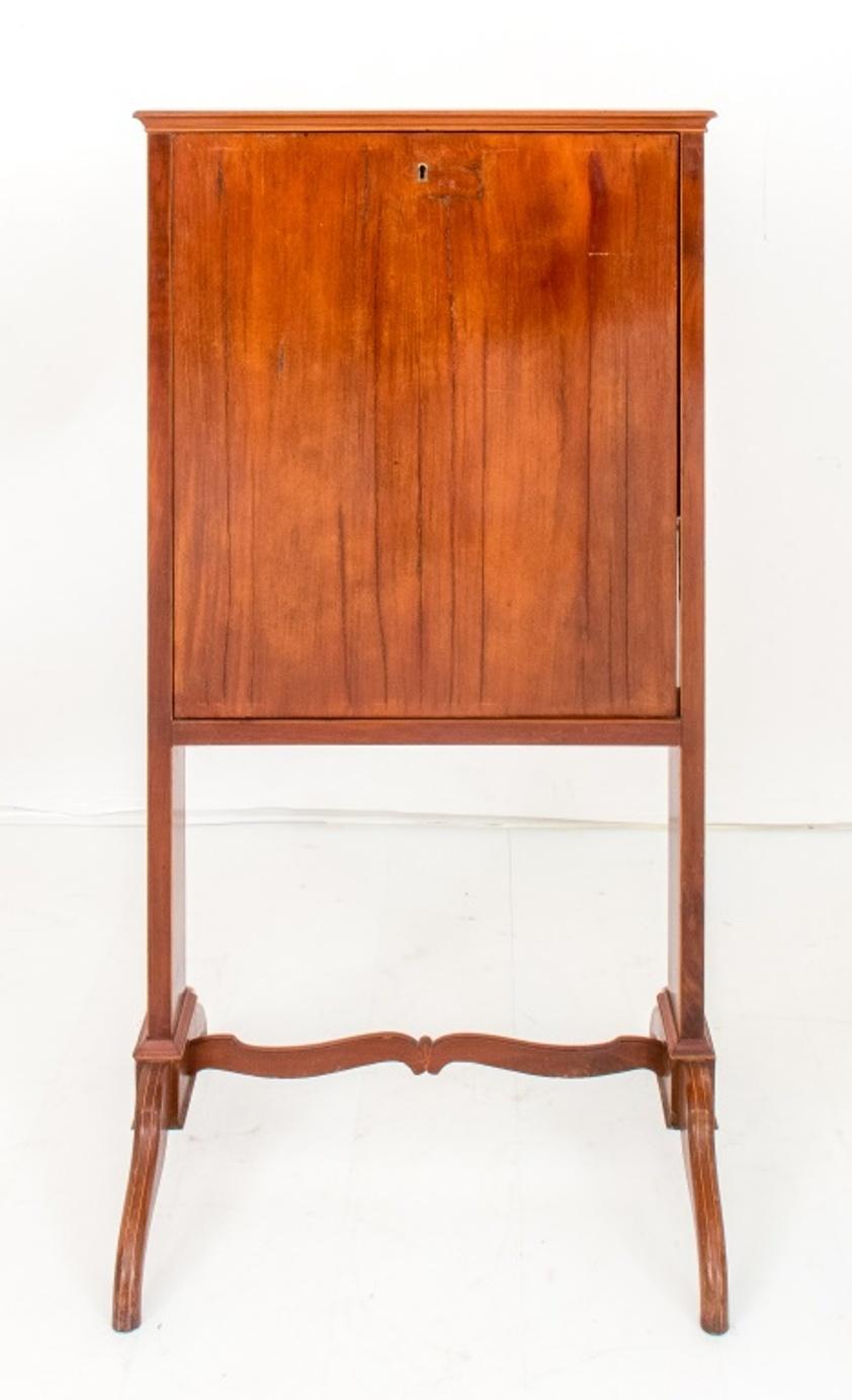 
George IV Mahogany firescreen secretary, ca. 1835, of tall rectangular form, the drop front writing surface opening to reveal a fitted interior with letter rack and drawers, supported on scroll feet with casters, 

Dimensions: 45
