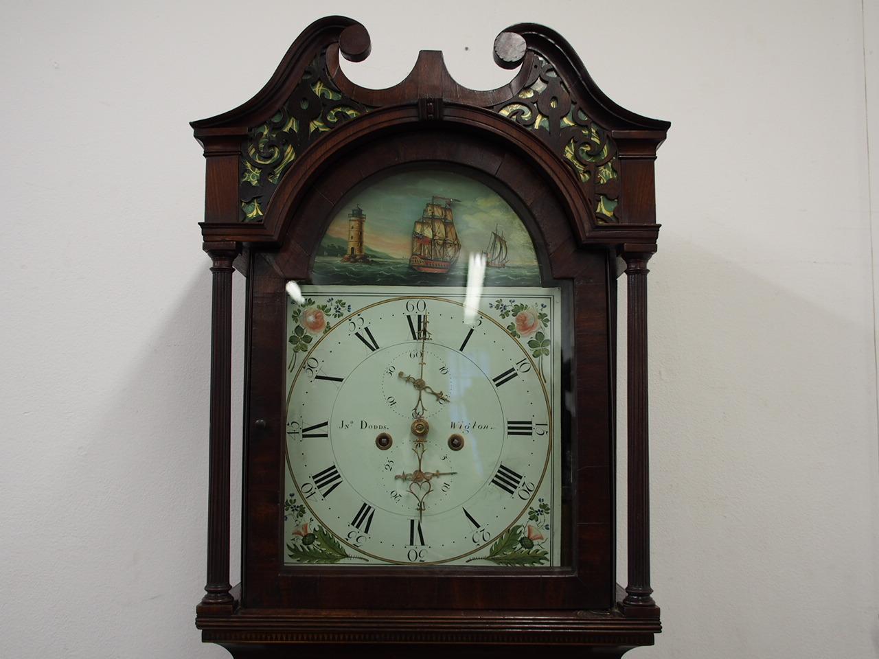 George IV mahogany and inlaid clock by J. John Dodds of Wigton, circa 1820. With painted face featuring a rocking ship mechanism and a nautical theme, a horn top and open fretwork panel. There are tapering columns to the case with inlaid shell