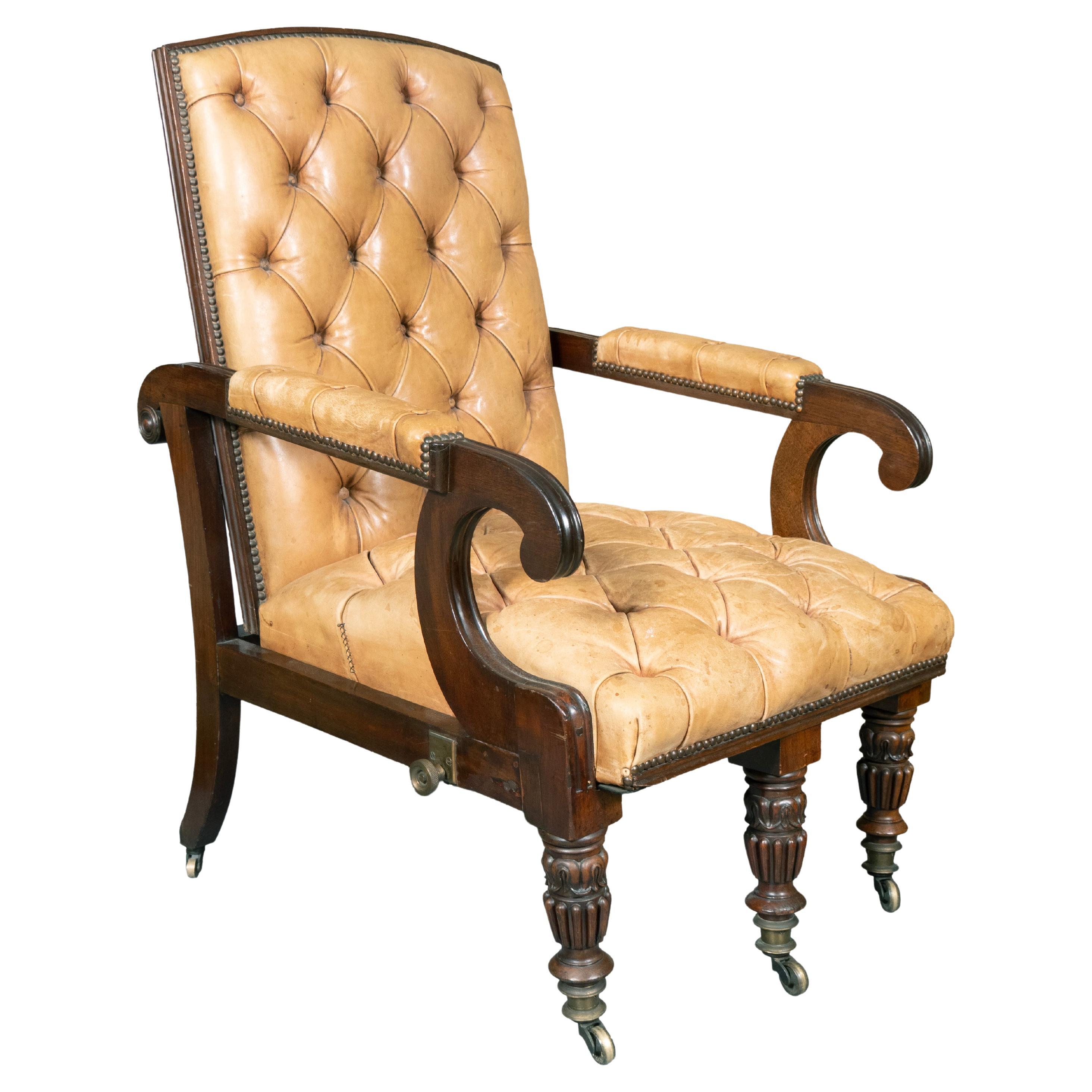 Upholstered in tufted light brown leather. The chair has the ability to recline. The brass knobs on side tighten to hold the seat at a set position. Most likely made by Gillows of Lancaster and London. With turned reeded legs with brass casters.