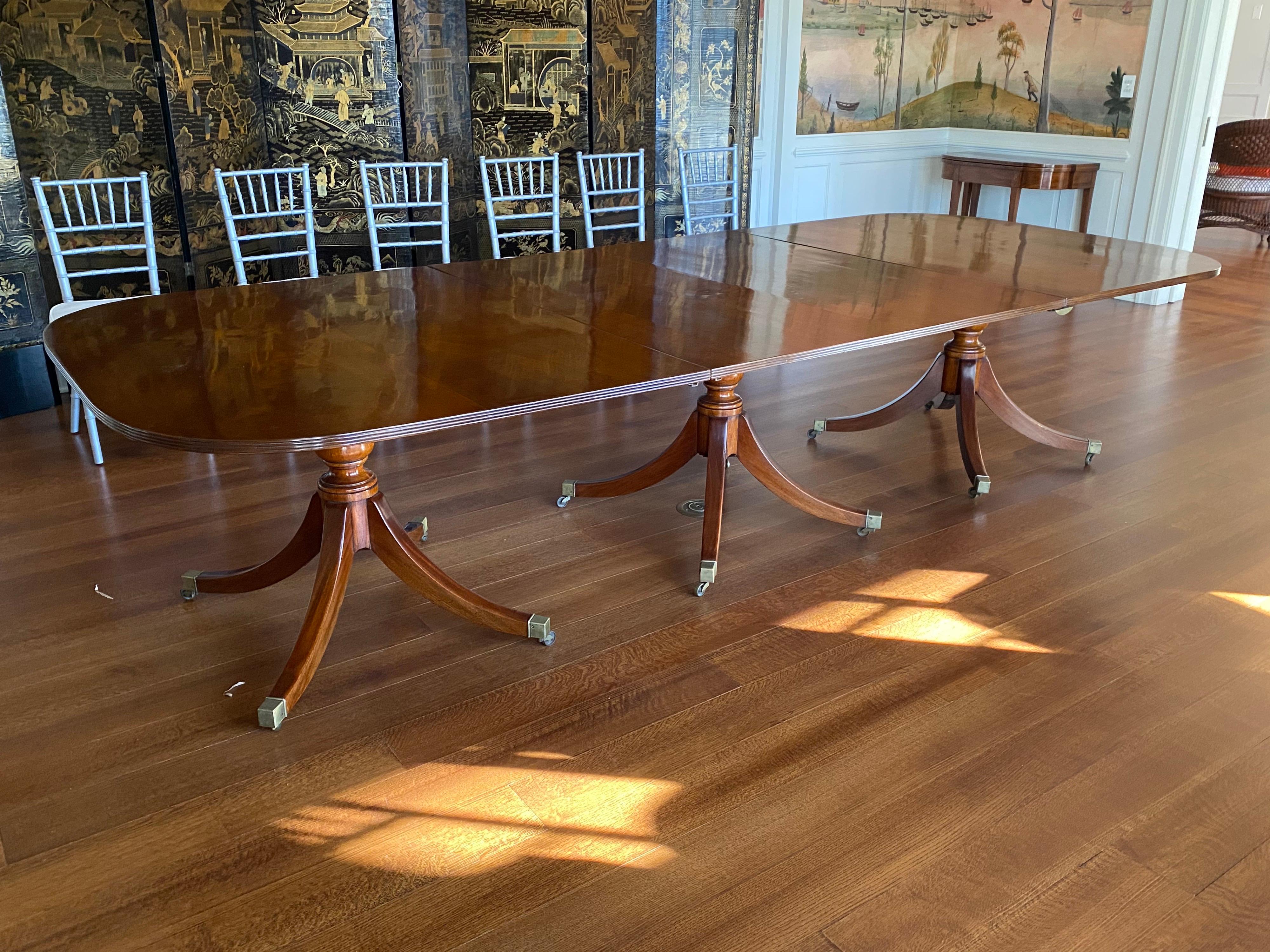 George IV mahogany three-pedestal dining table, circa 1825
The D-shaped top with reeded edge raised on ring-turned supports issuing down swept legs ending in brass caps and casters. With two 18.5