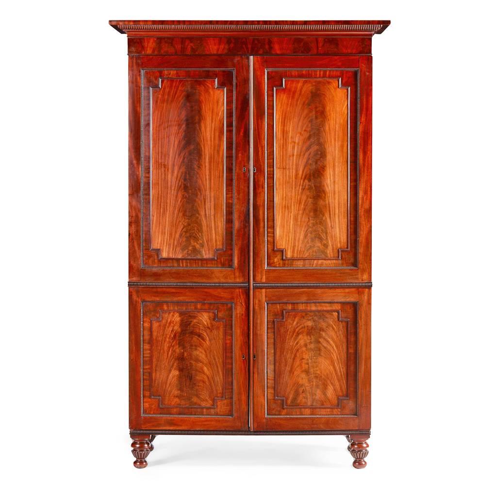 Good two-door wardrobe by William Trotter of Edinburgh, with wonderful selected mahogany veneers and extensive use of flame mahogany, circa 1820. The cornice has a protruding top section which is cross banded above wonderful form of gadrooning in