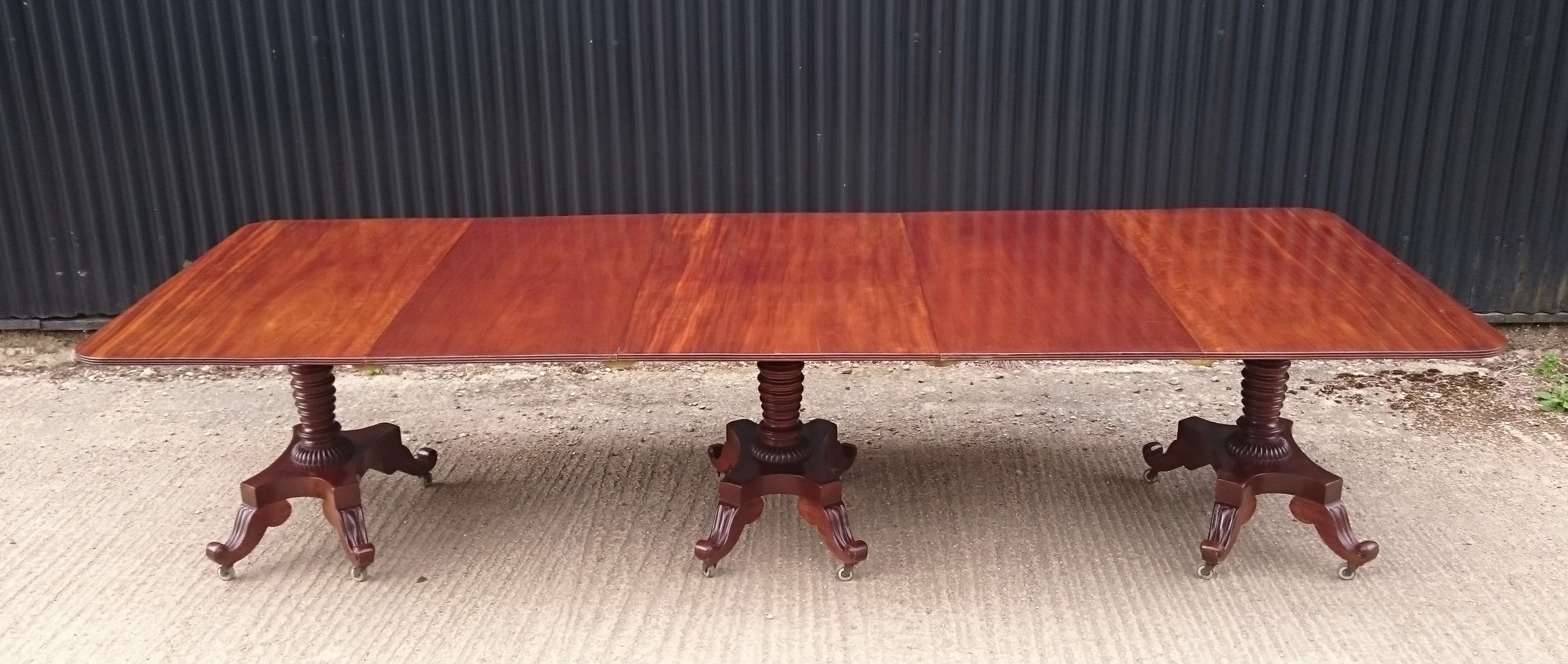 Antique dining table dating from circa 1825, this George IV period mahogany antique dining table is supported by three pedestals, each with four splay legs and it has two removable leaves to adjust the length of the table to suit the number of